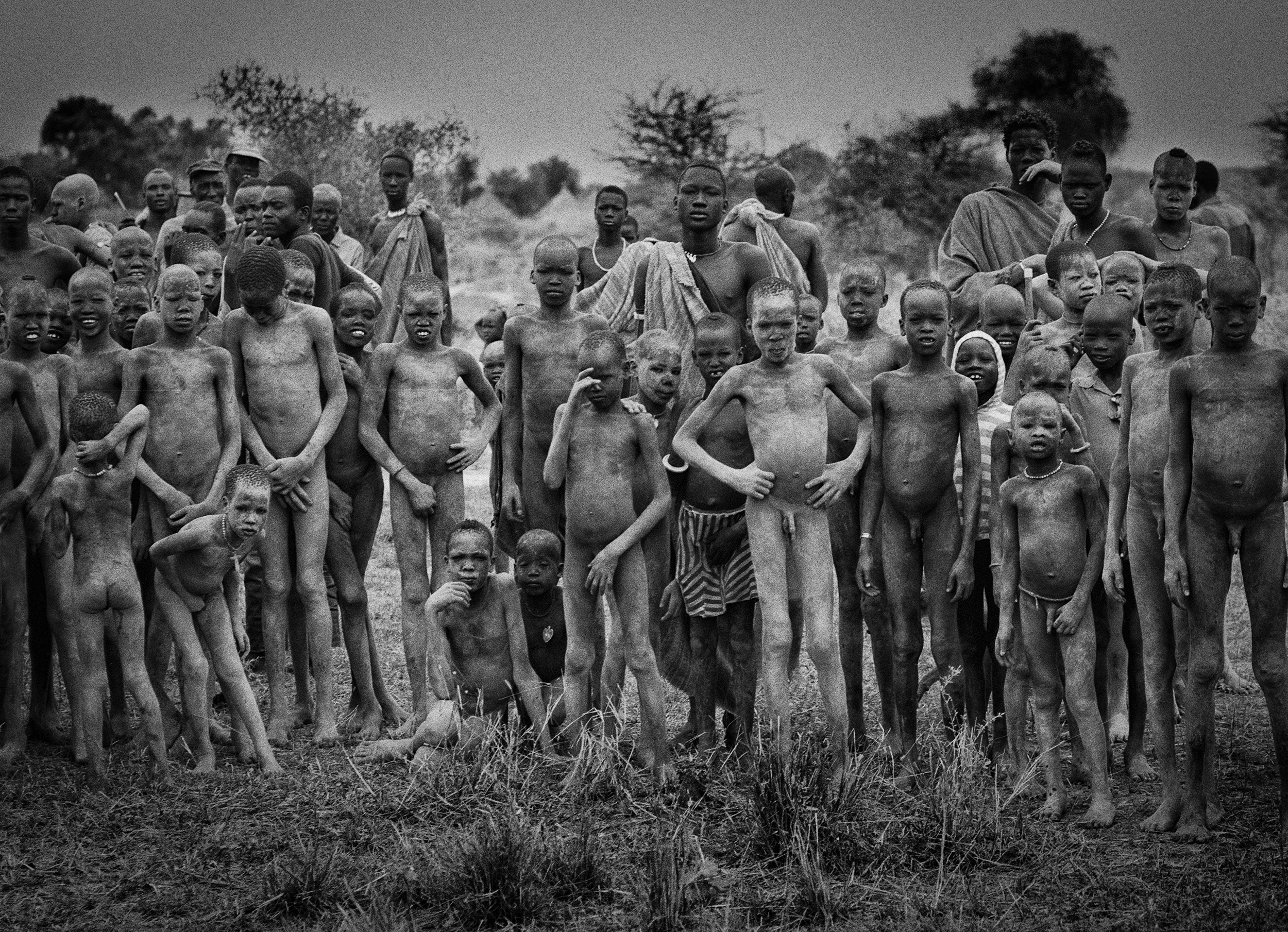 The children go unclothed until puberty - their initiation into adulthood includes being cut on their face - often in a chevron pattern