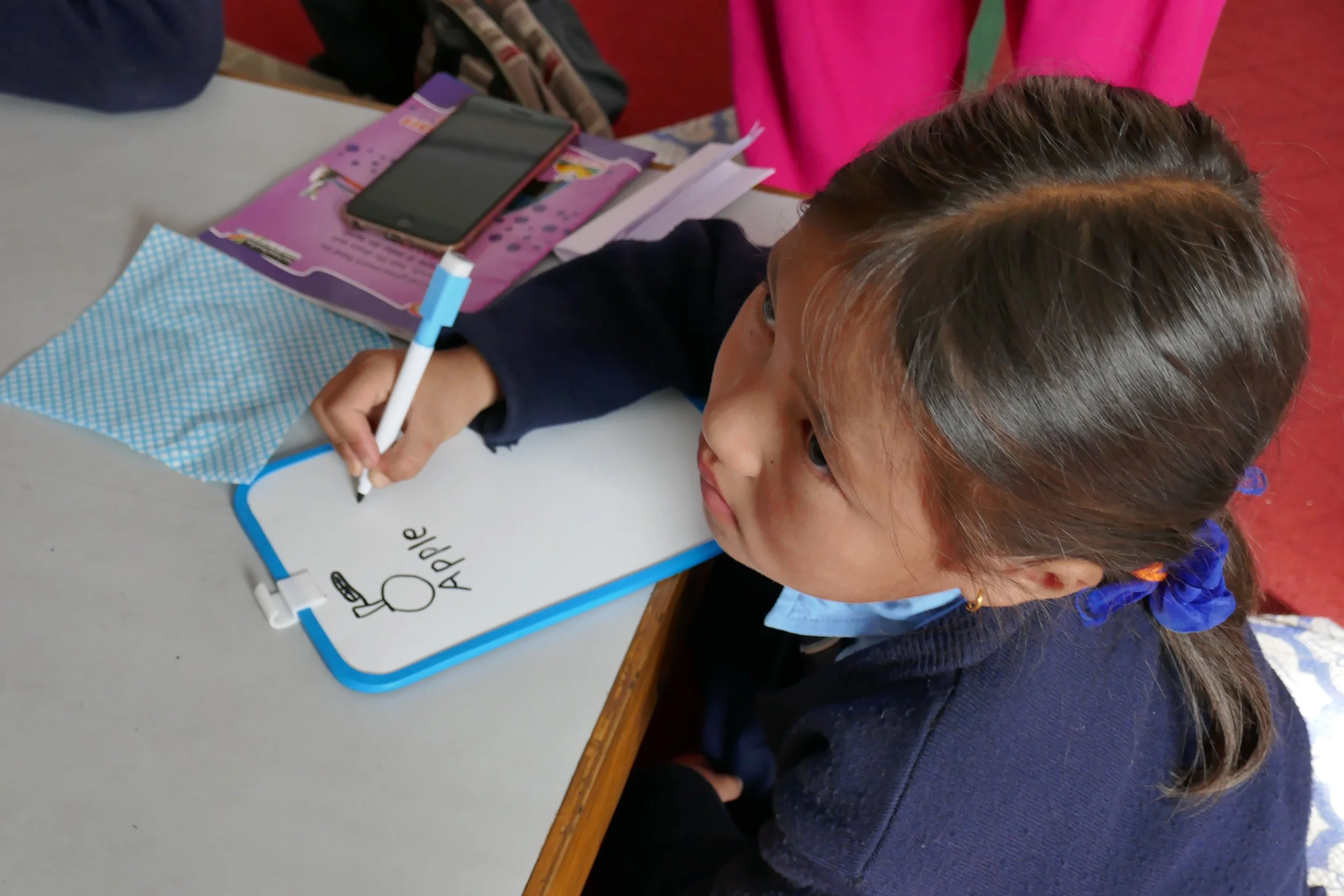 Student in Melamchi Ghyang School in Nepal drawing pictures of fruits and writing their names