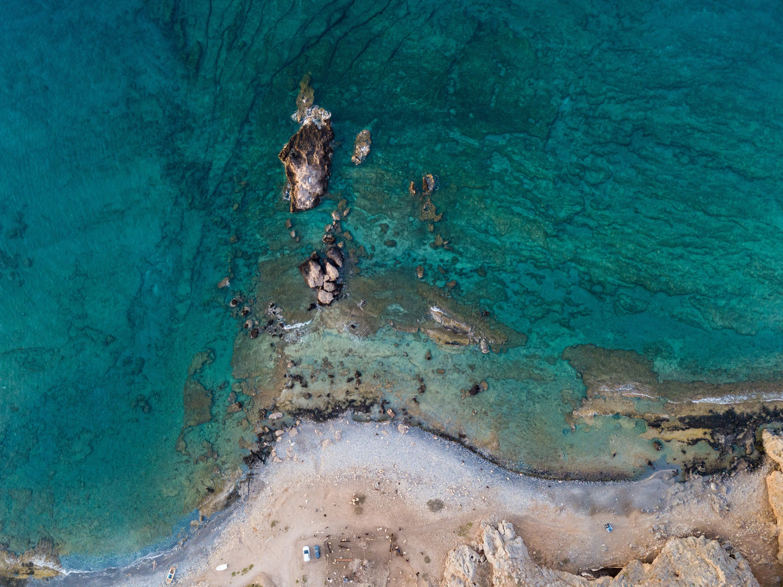 Drone Overhead at Likos. Can you see me? I’m above the cars close to the water, the speck of black on the grey rock by the water.