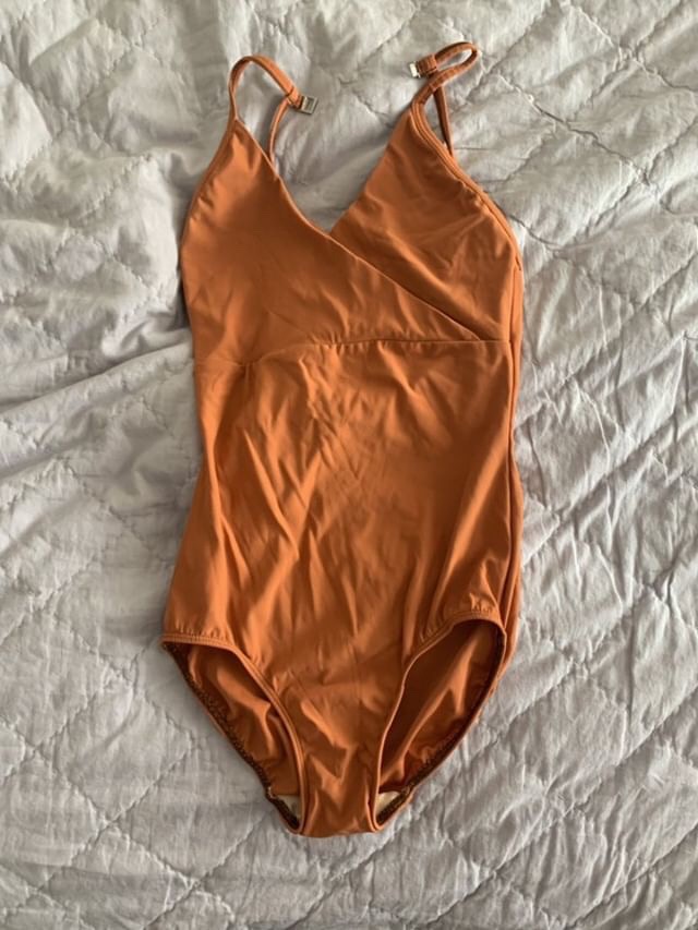 Orange bodysuit rock waterfall
