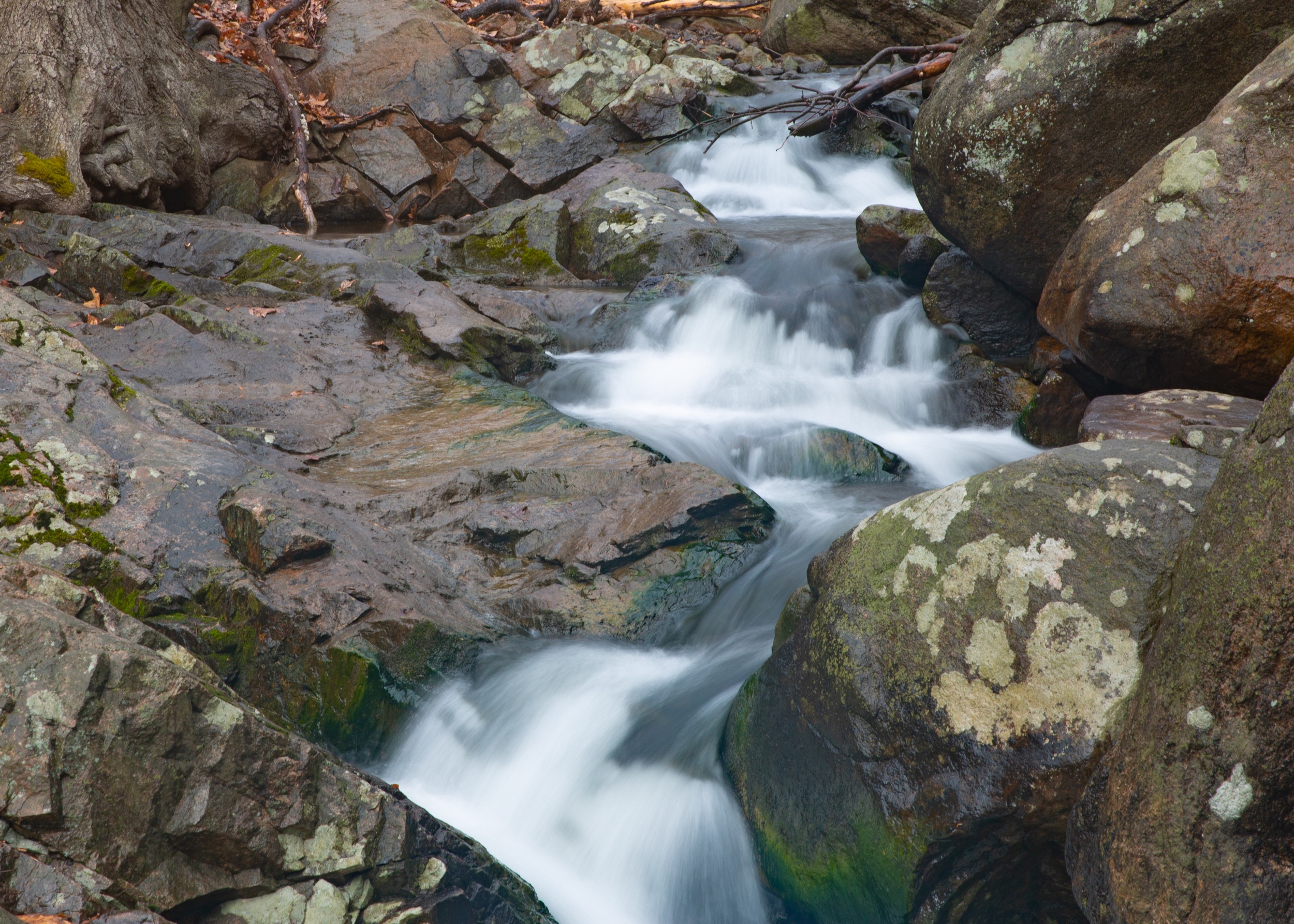 Colorful rocks- waterfall drone shot from above- mesh skirt or something with fabric