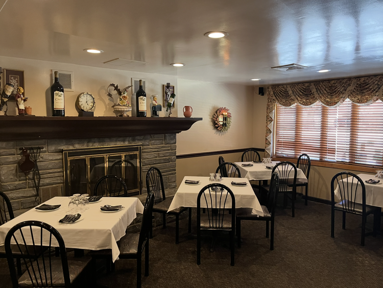 Fieni's dining room with white tablecloths and a stone fireplace
