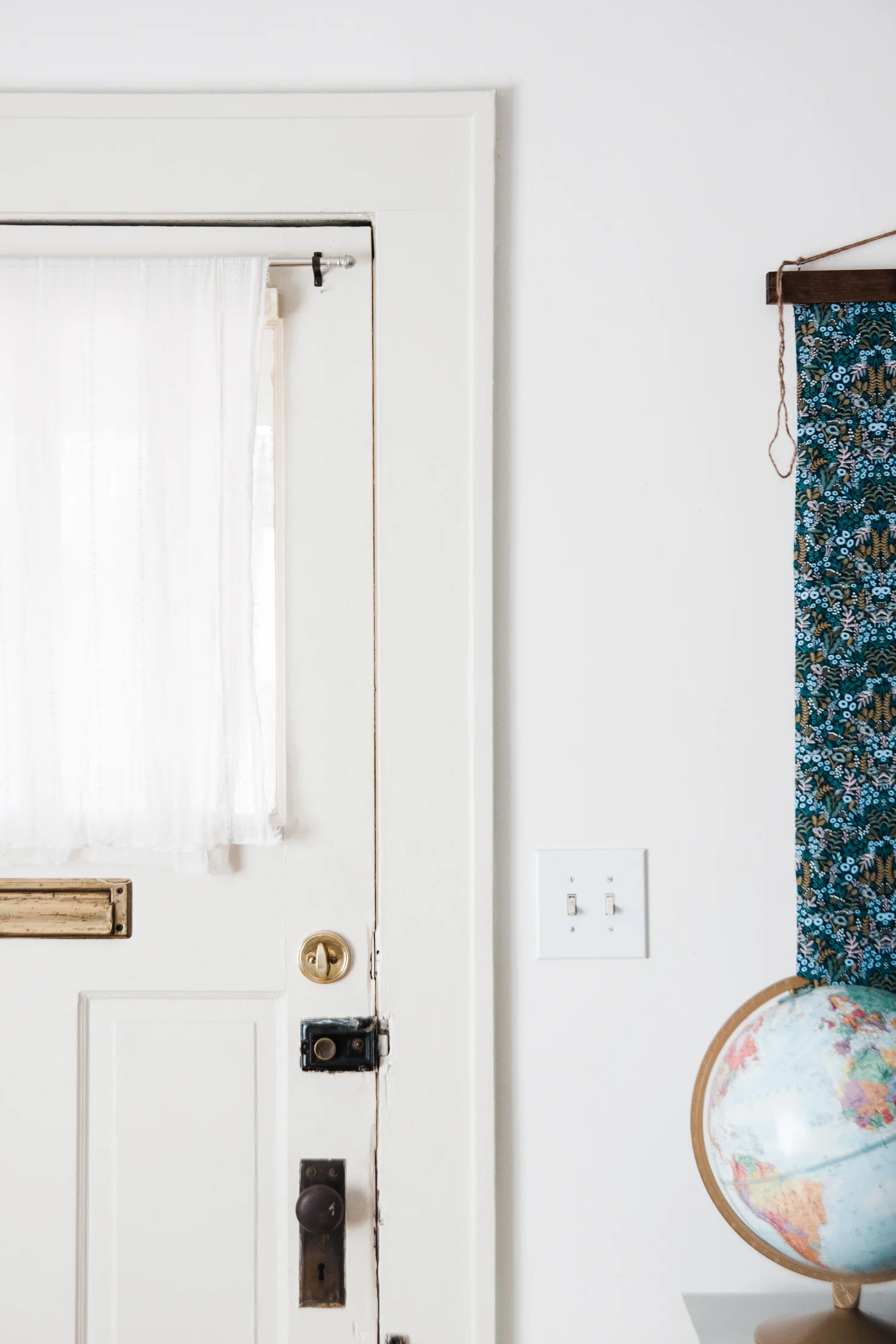 Emily draped a simple vintage scarf over the window of her front door for privacy.