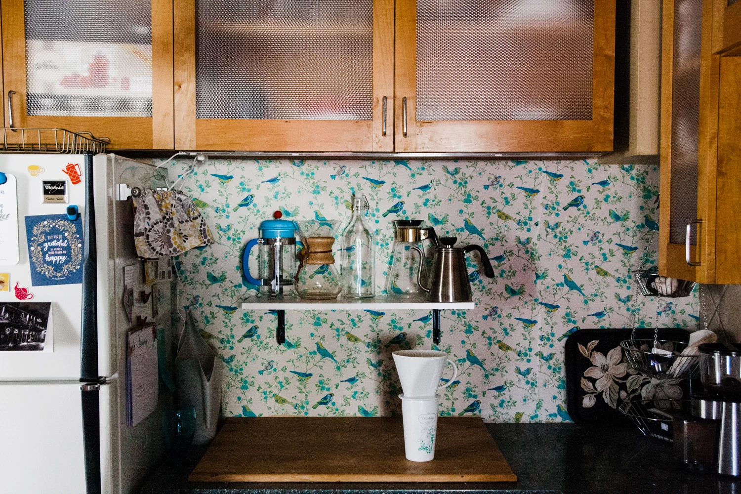The colorful bird backsplash is fabric that Emily installed herself.