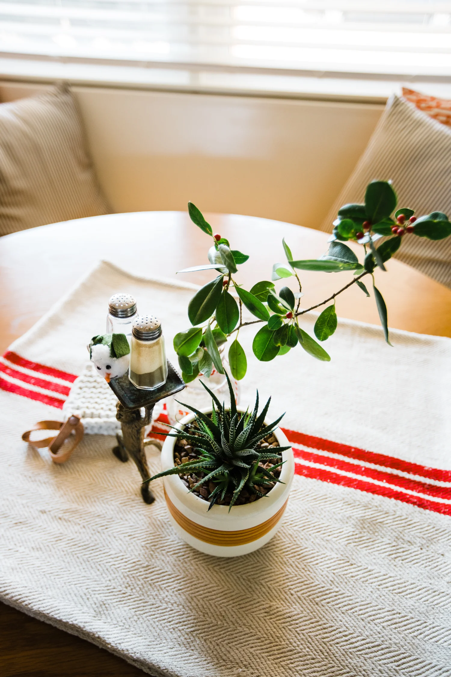 My trusty red striped grain sack (from the first year we owned Retro Den) graced the eat-in table this year. And a branch from our weird holly tree-bush plus a succulent and a snowman head makes for a festive eating experience.