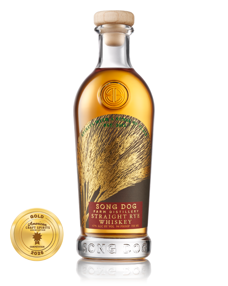 A bottle of Song Dog Farm Distillery Straight Rye Whiskey with a gold medal beside it.
