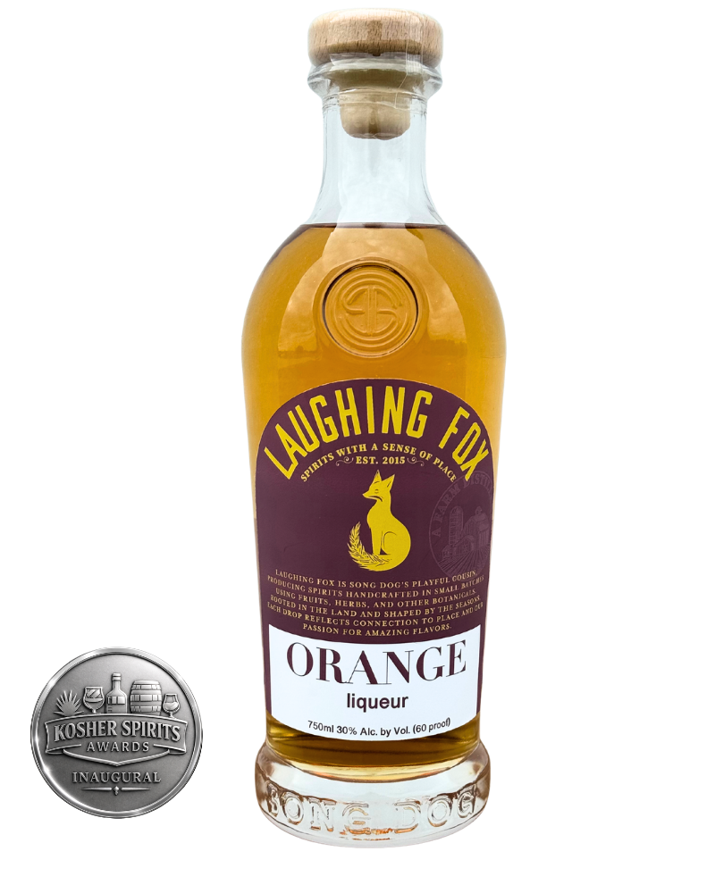A bottle of Laughing Fox Orange Liqueur with a cork top and a purple and white label featuring a fox silhouette and the text "Laughing Fox" and "Orange Liqueur." A silver Kosher Spirits Award badge is in the lower left corner.