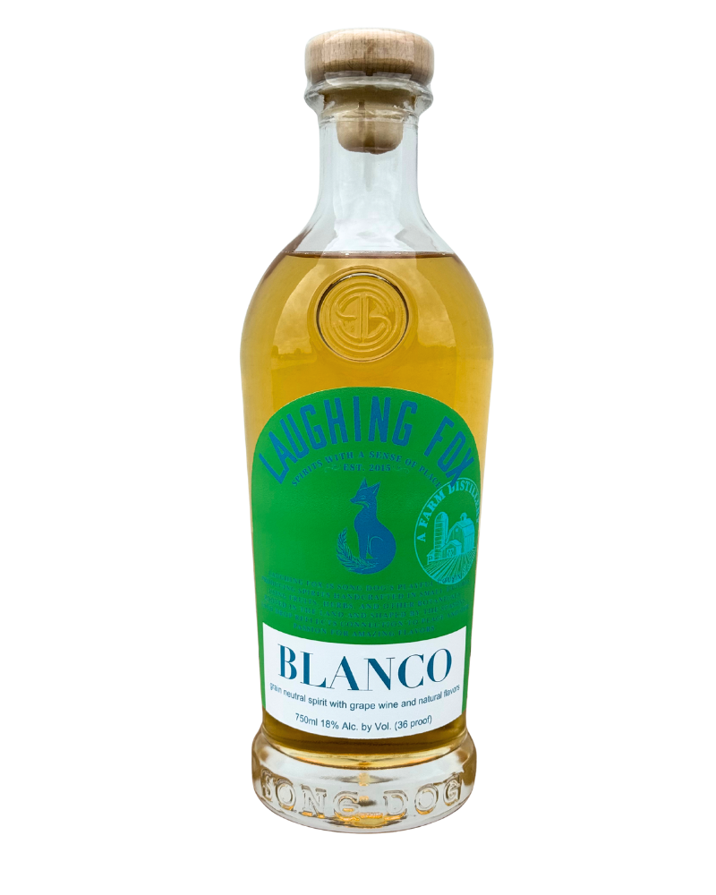 A clear glass bottle of laughing fox blanco spirit with a cork stopper, featuring a green and blue label indicating it's a neutral spirit with grape wine and natural flavors, 750ml, 18% alcohol.