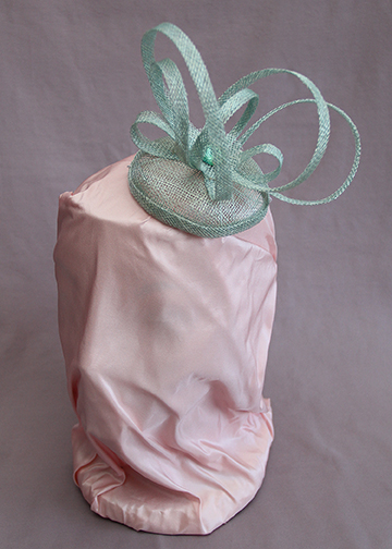 Sea foam green sinamay fascinator with loops and vintage glass button