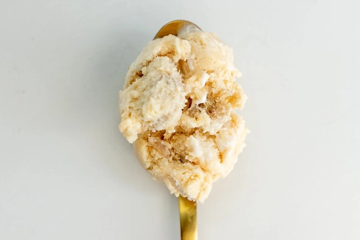 A spoonful of cookies and cream ice cream with cookie chunks on a white background.