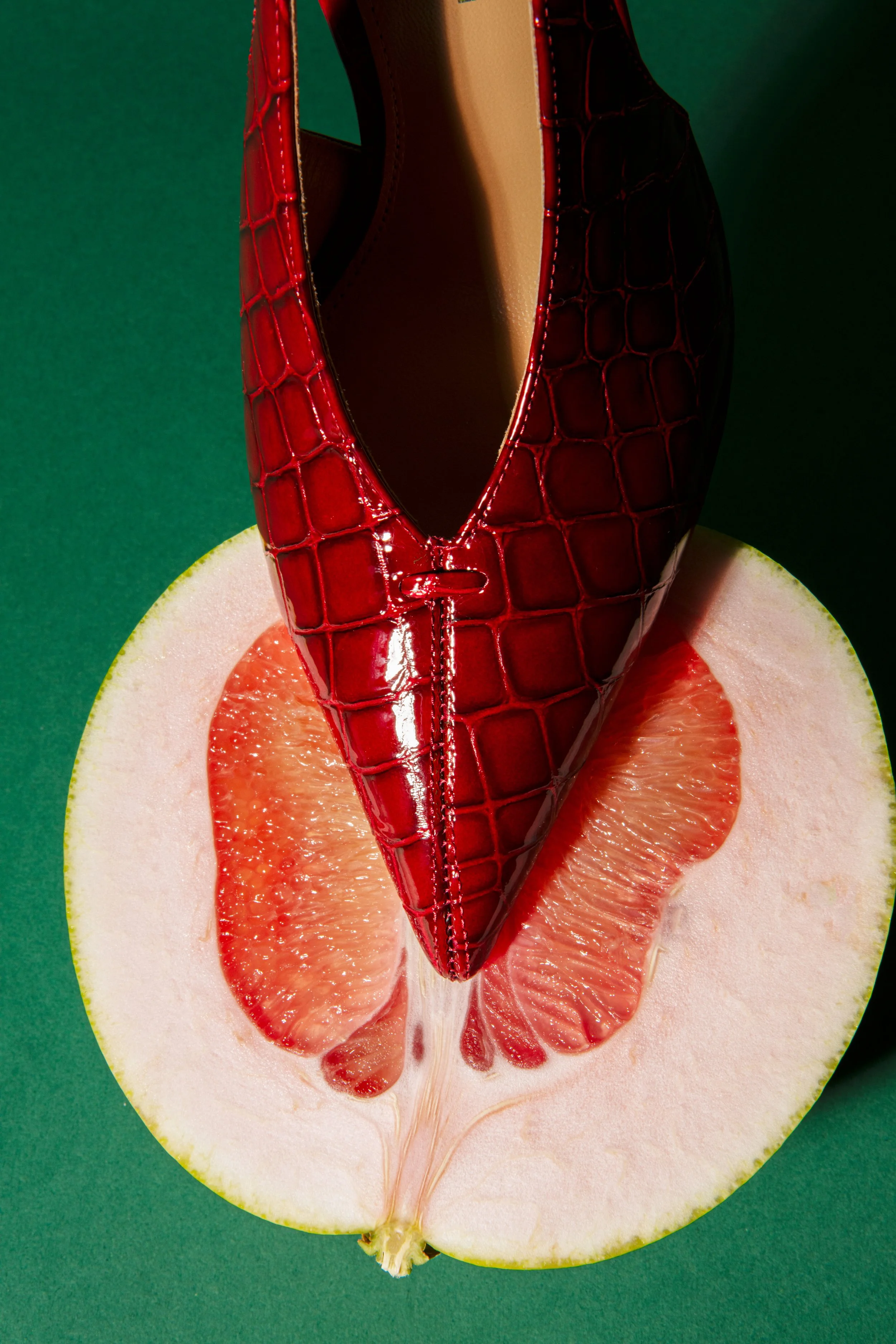  red shoes whit pomegrade fruits on a green backdrop 