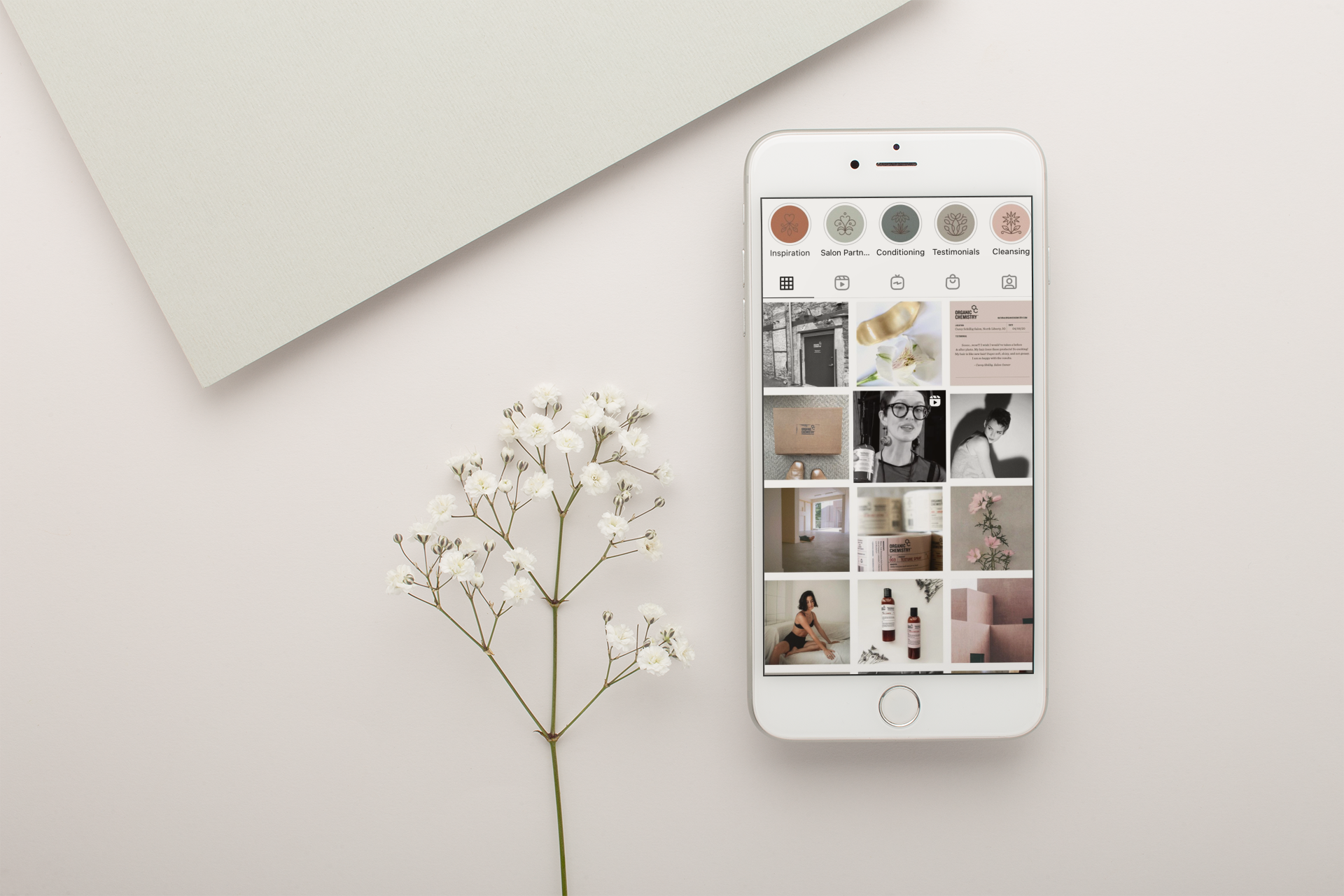 silver-iphone-mockup-lying-next-to-small-white-flowers-22019.png