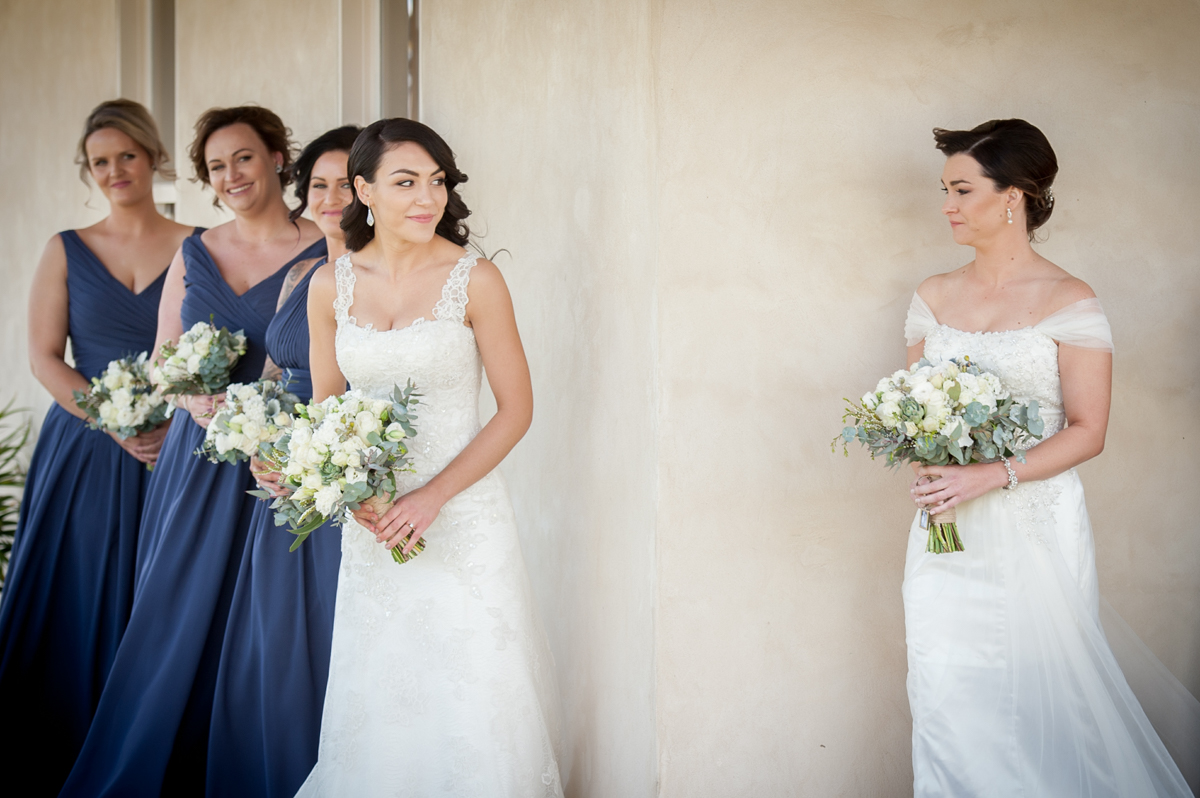 2 brides see each other for the first time on their commitment ceremony day.