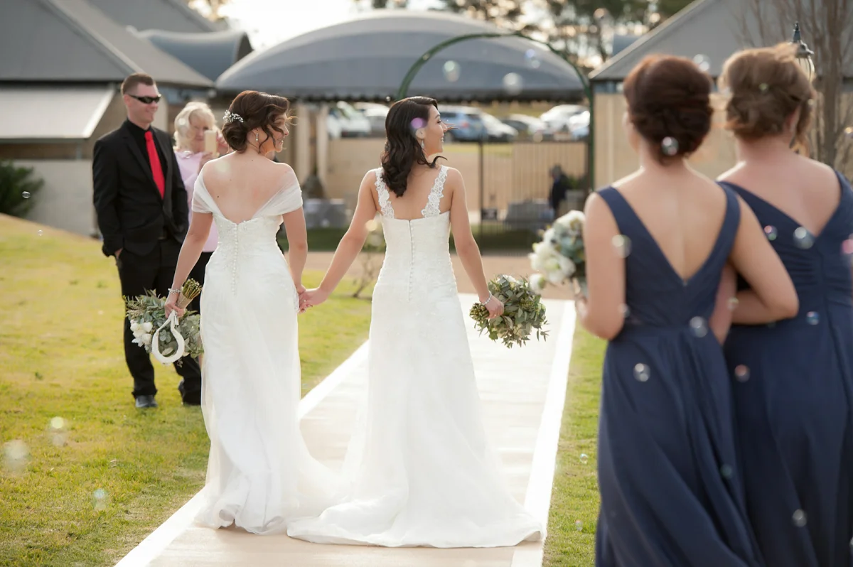 brides walk down the aisle together after their commitment ceremony