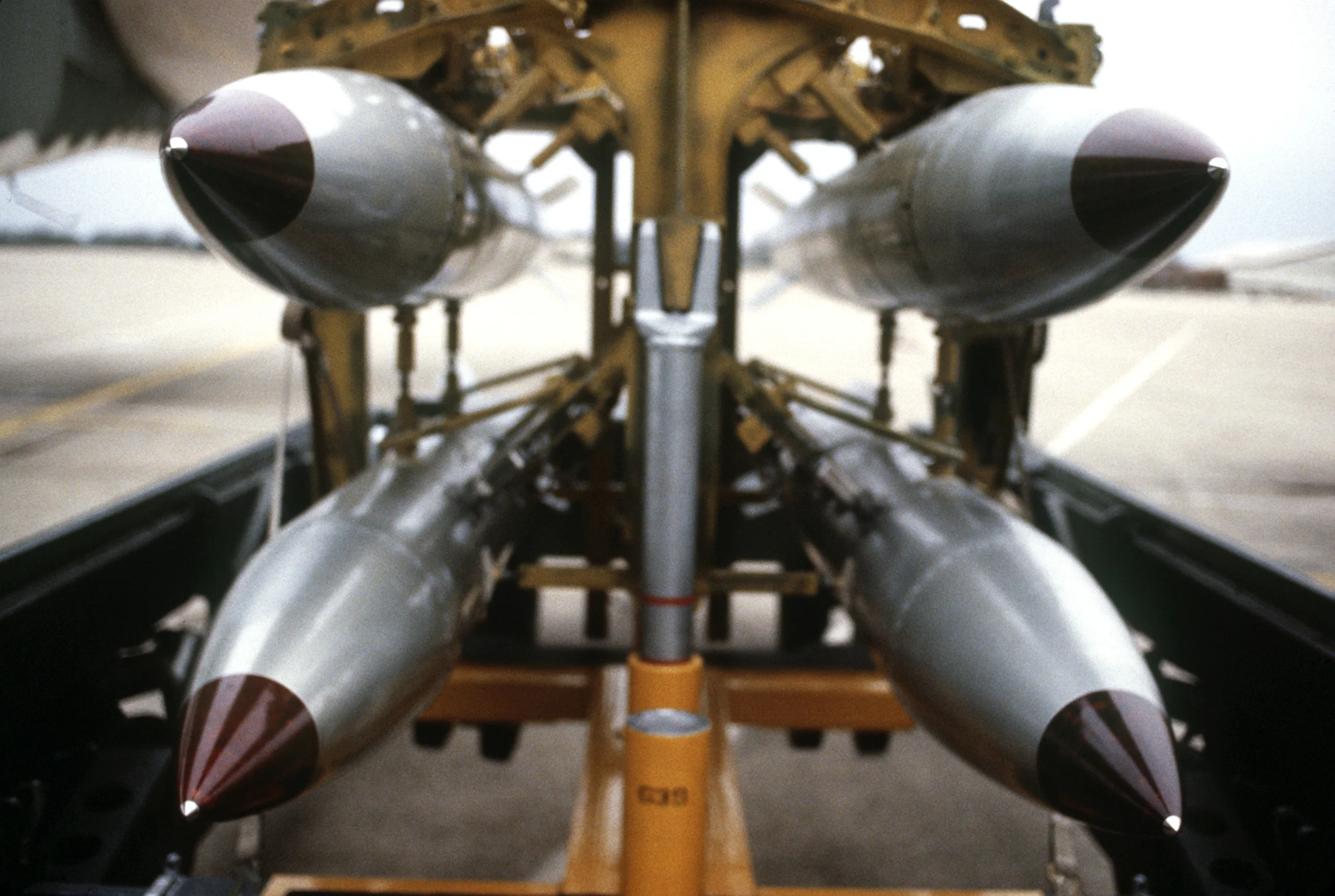 US B-61 Nuclear bombs on a bomb rack, raised from their storage site for mounting on an aircraft. SOURCE: United States Department of Defense (SSGT Phil Schmitten) - DefenseLINK Multimedia Gallery , asset DFST8712392.