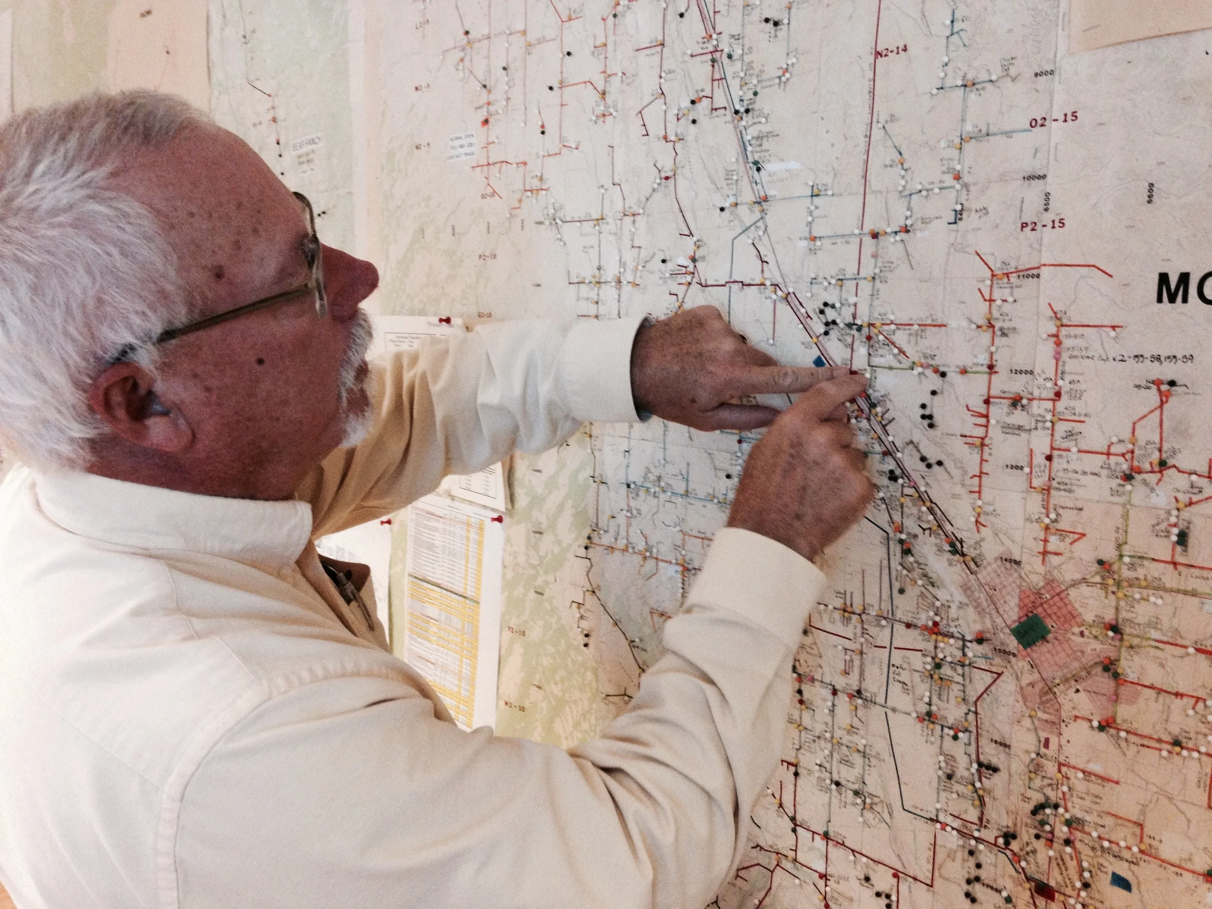 Steve Metheny, of the Delta-Montrose Electric Association, illustrates the utility's back-up to the back-up: a floor to ceiling paper map of their service area and infrastructure. Jordan Wirfs-Brock.
