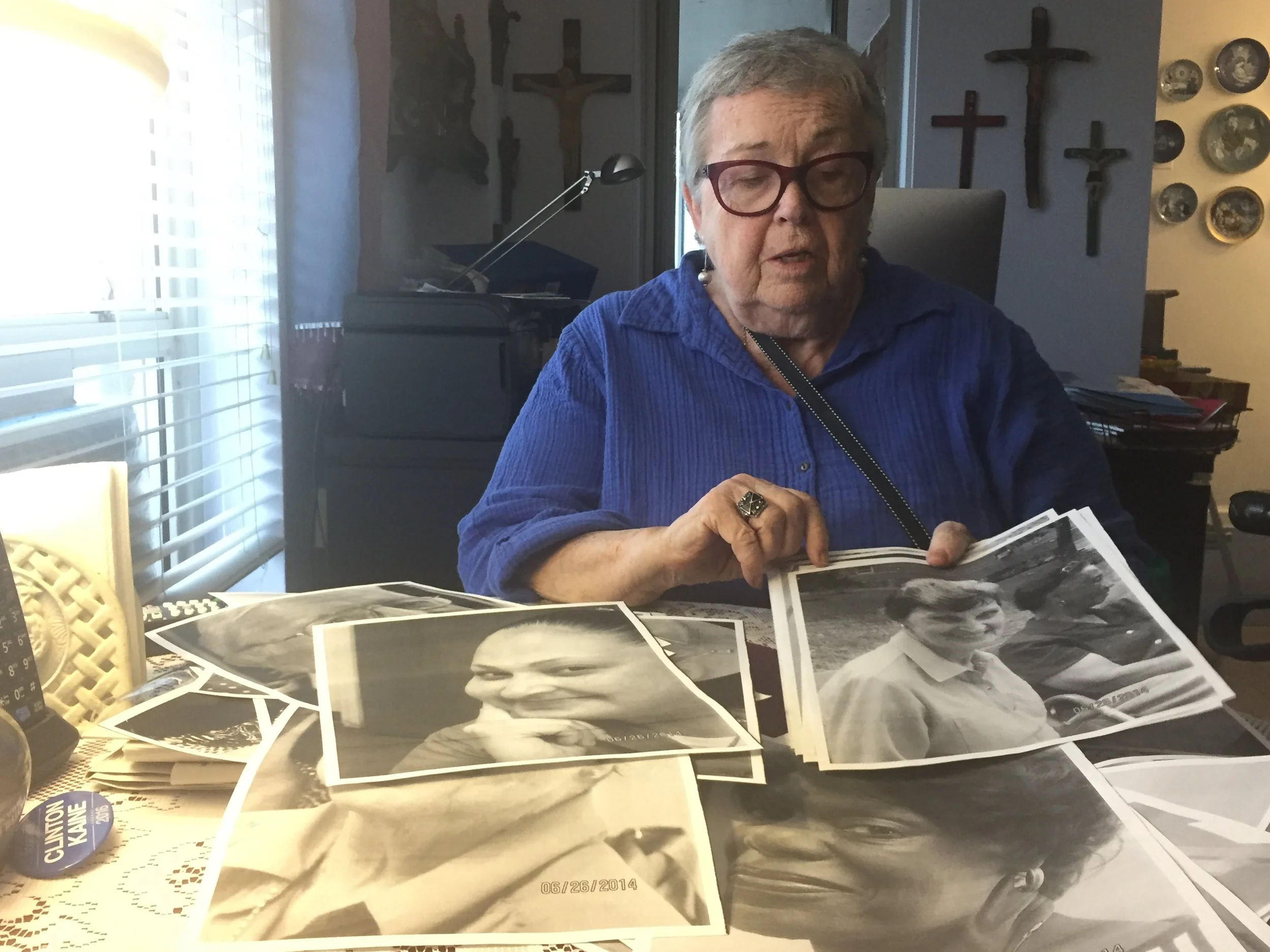 Eileen Canty, 83, shows photos of Morningside Gardens NORC residents at her home. (Photo: Emily Dugdale). 