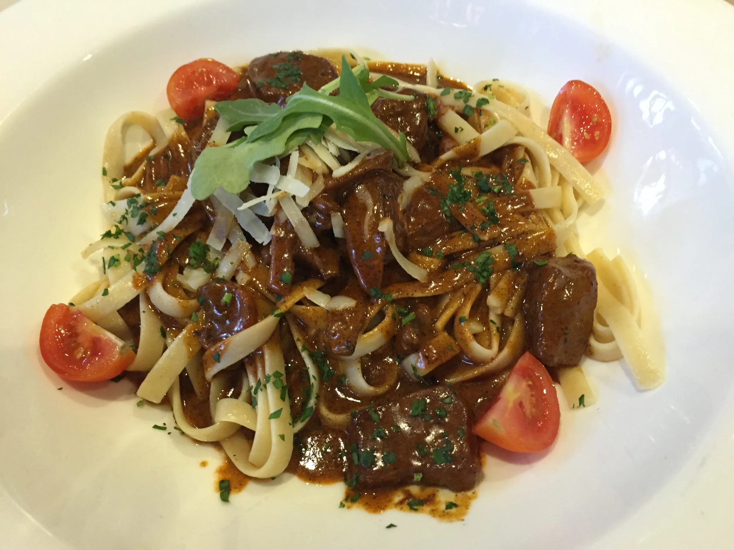 Filet Tips in pasta with brown gravy anf cherry tomatoes