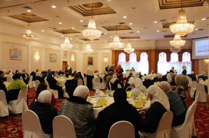 A crowded room of Islamic women listen intently to the Sheikha talk about the importance of good deeds. (Photo by Charlotte Grieve)