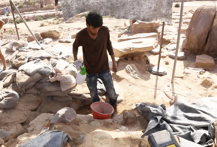 An archaeologist makes mortar to shore up walls.