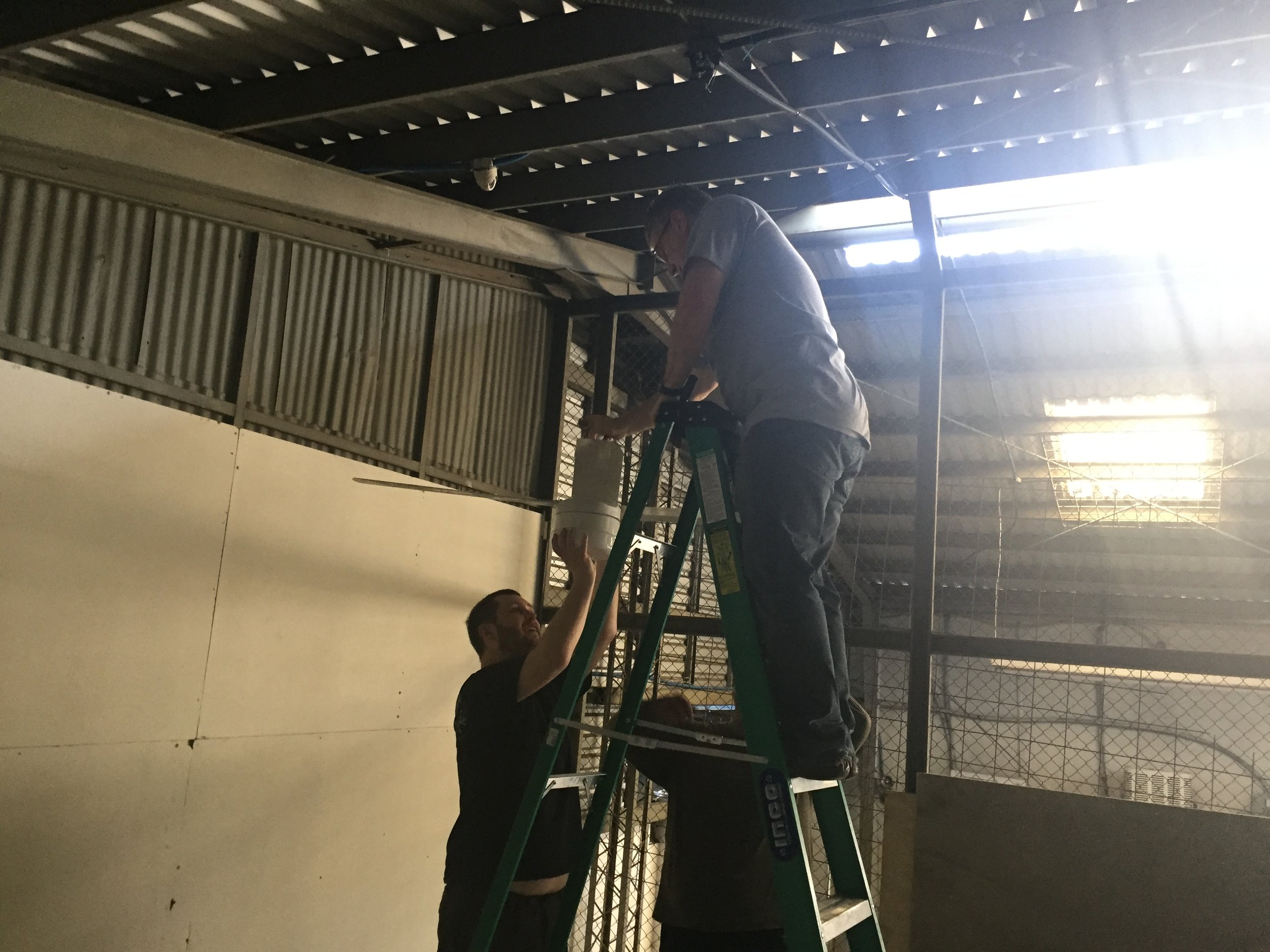 Paul and Sean hanging a ceiling fan. 