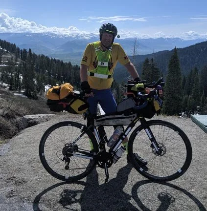 Mark with his bicycle atop a mountain pass