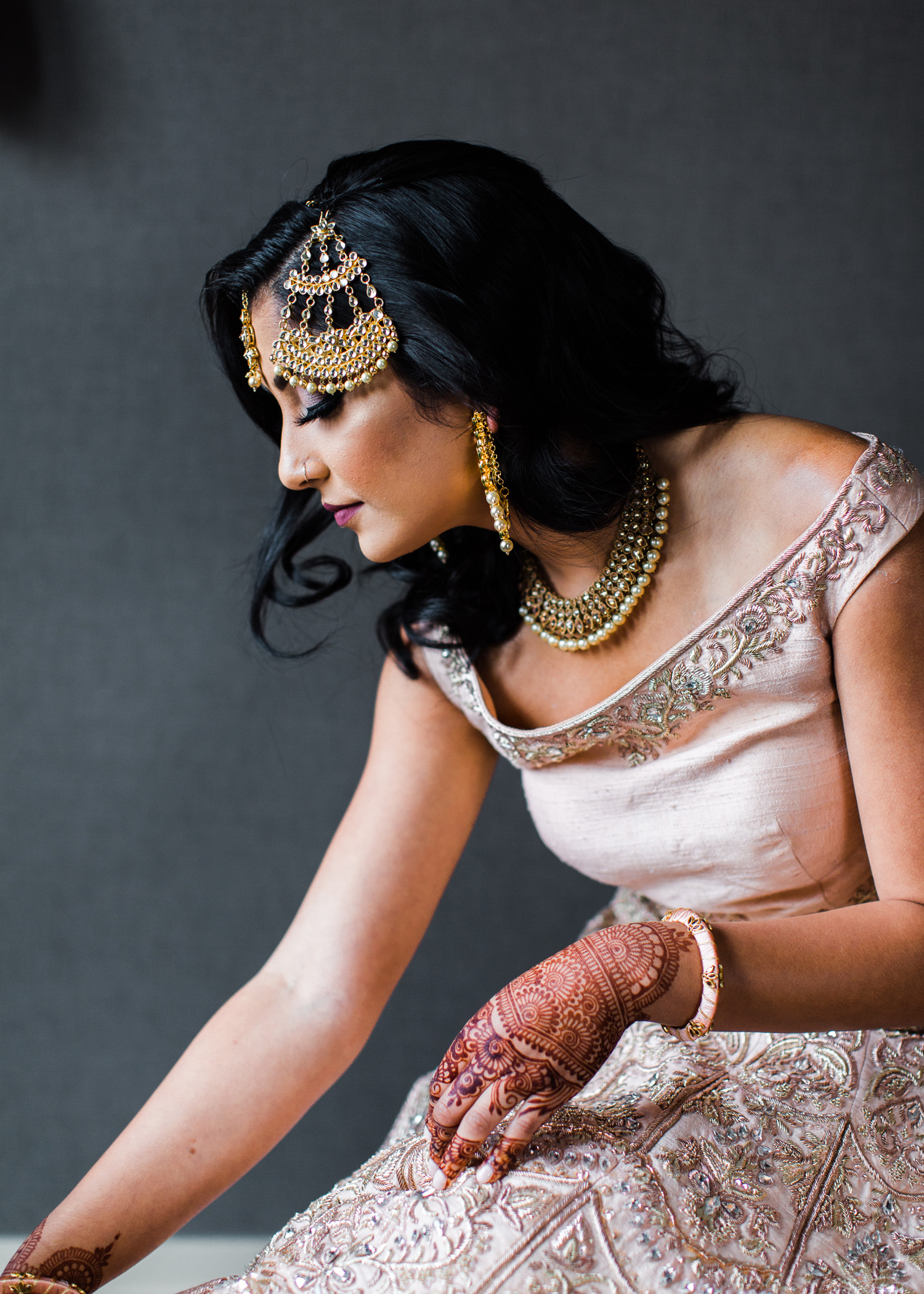 Alexandra Knight Photography Seattle Indian Wedding Photographer bride getting dressed blush pink lehenga dress with gold jewelry and henna.jpg