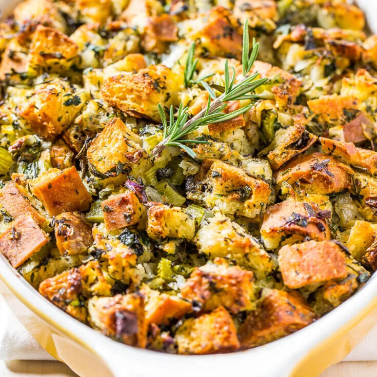 Baked stuffing with chunks of bread, celery, herbs, and a sprig of rosemary on top. - Catering Chef Kansas City