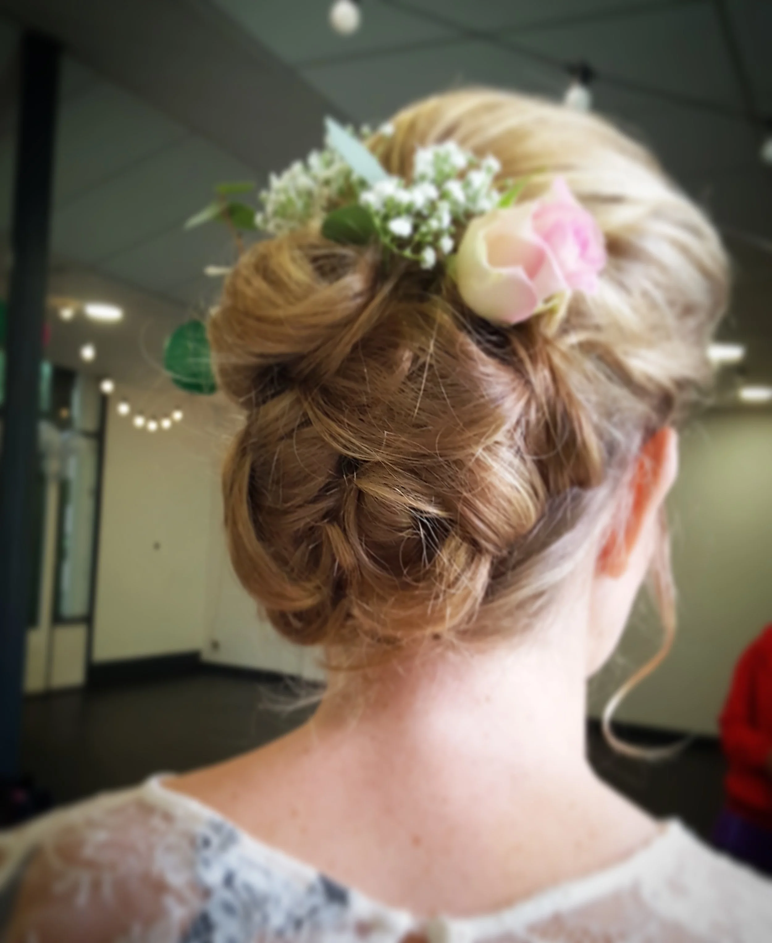 Bruidskapsel met bloemen op locatie