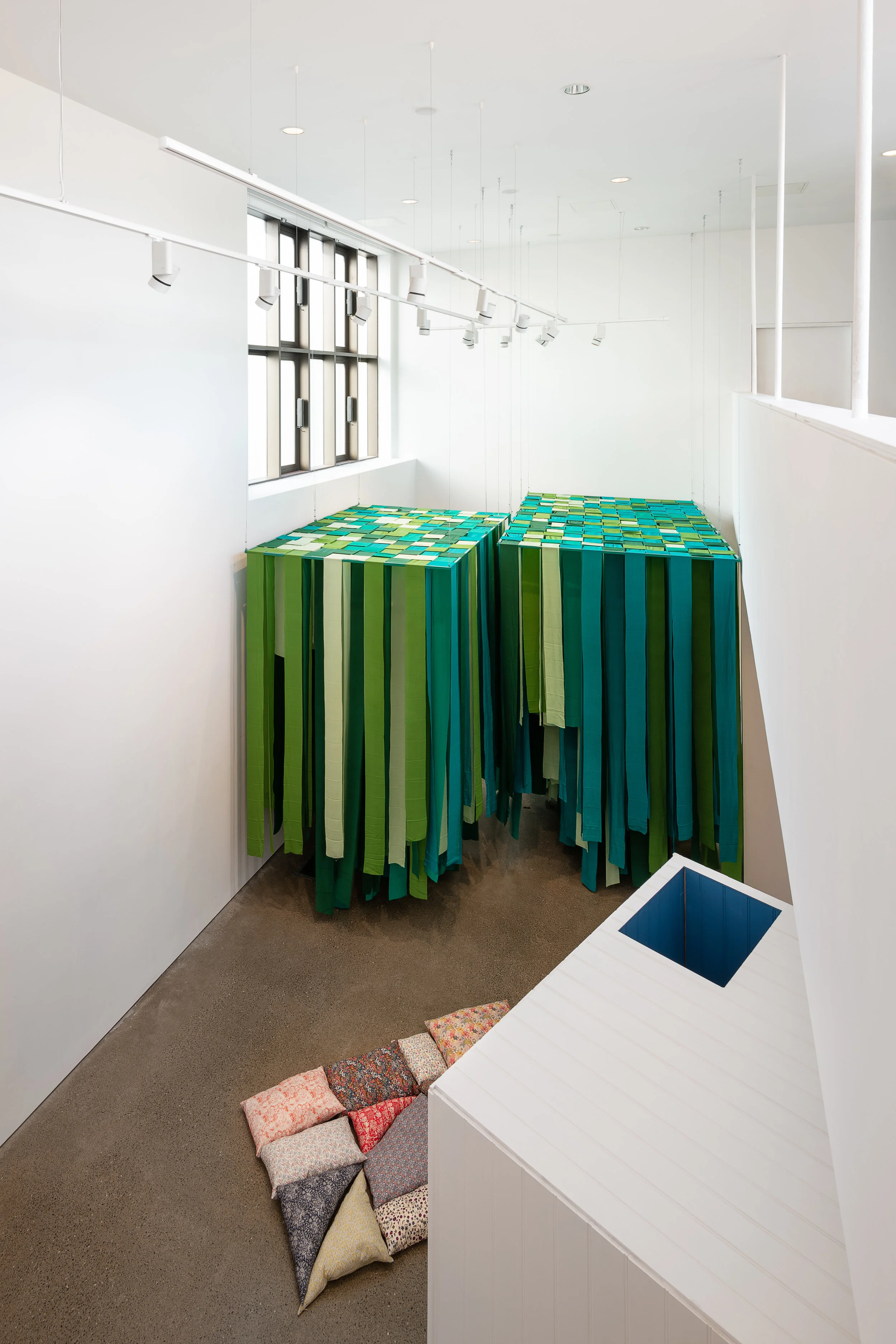 View from balcony Centre - Mobile Element - Cushions for arranging, and sitting or lying on; fabric, cushion filler; Right - Element 2 (passageway), painted wood; Background - Element 1 (green canopy), powdered steel, silk Caoimhe Kilfeather Photo by Jed Niezgoda