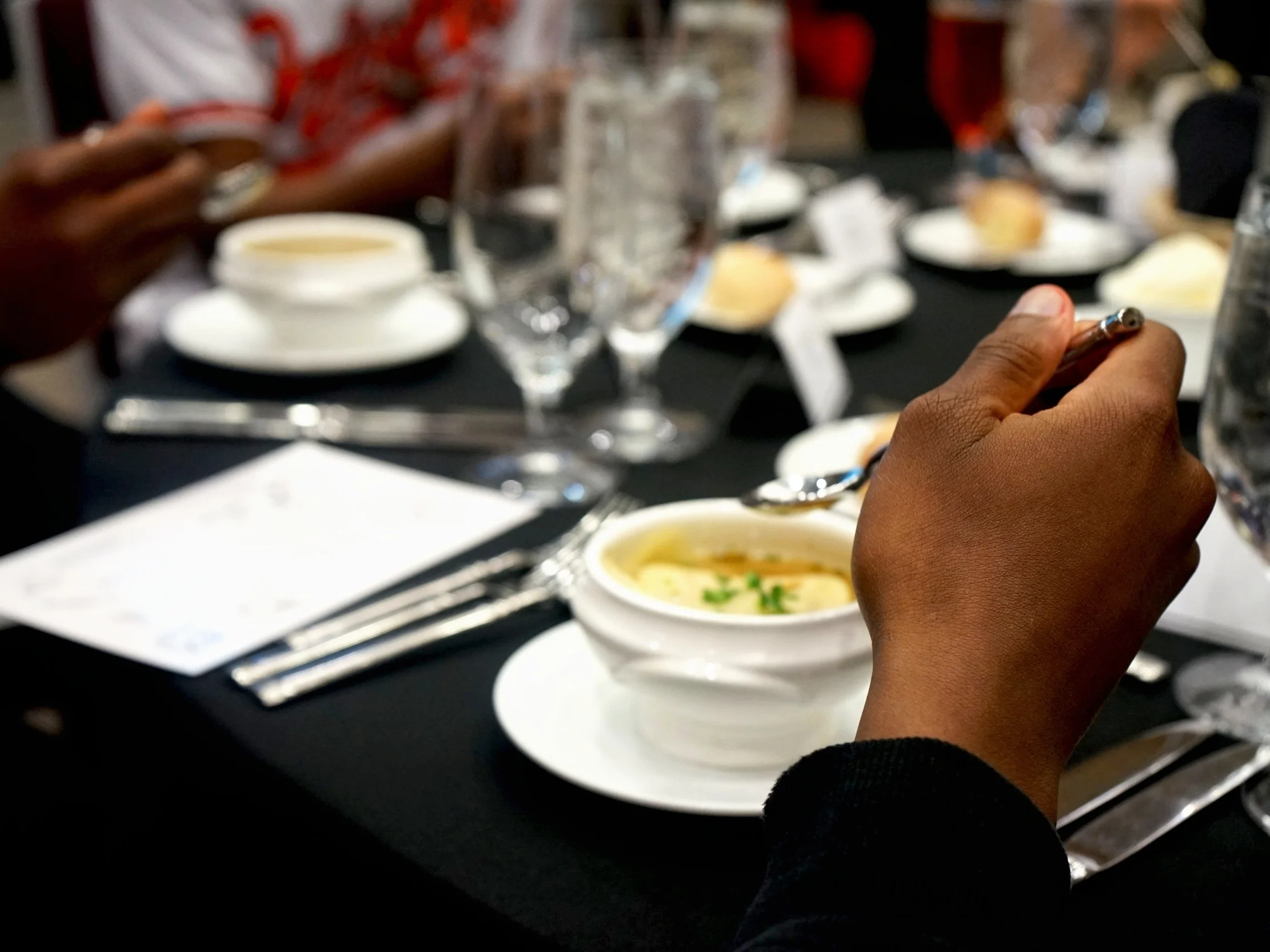 Students exhibit the proper spoon placement during the meal’s first course.