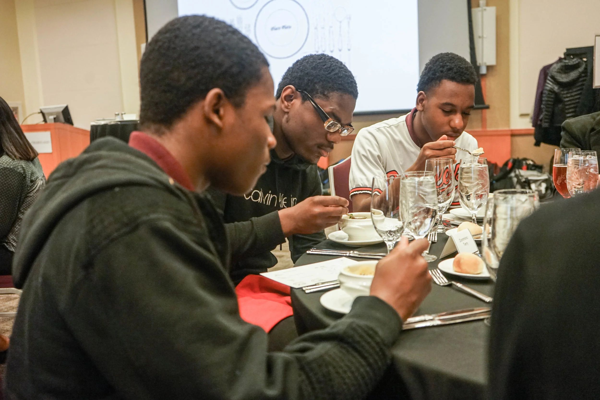 Three students from Renaissance Academy High School cool their soup. French onion soup was the first course of a four-course etiquette dinner at the SMC Campus Center, U of Maryland.