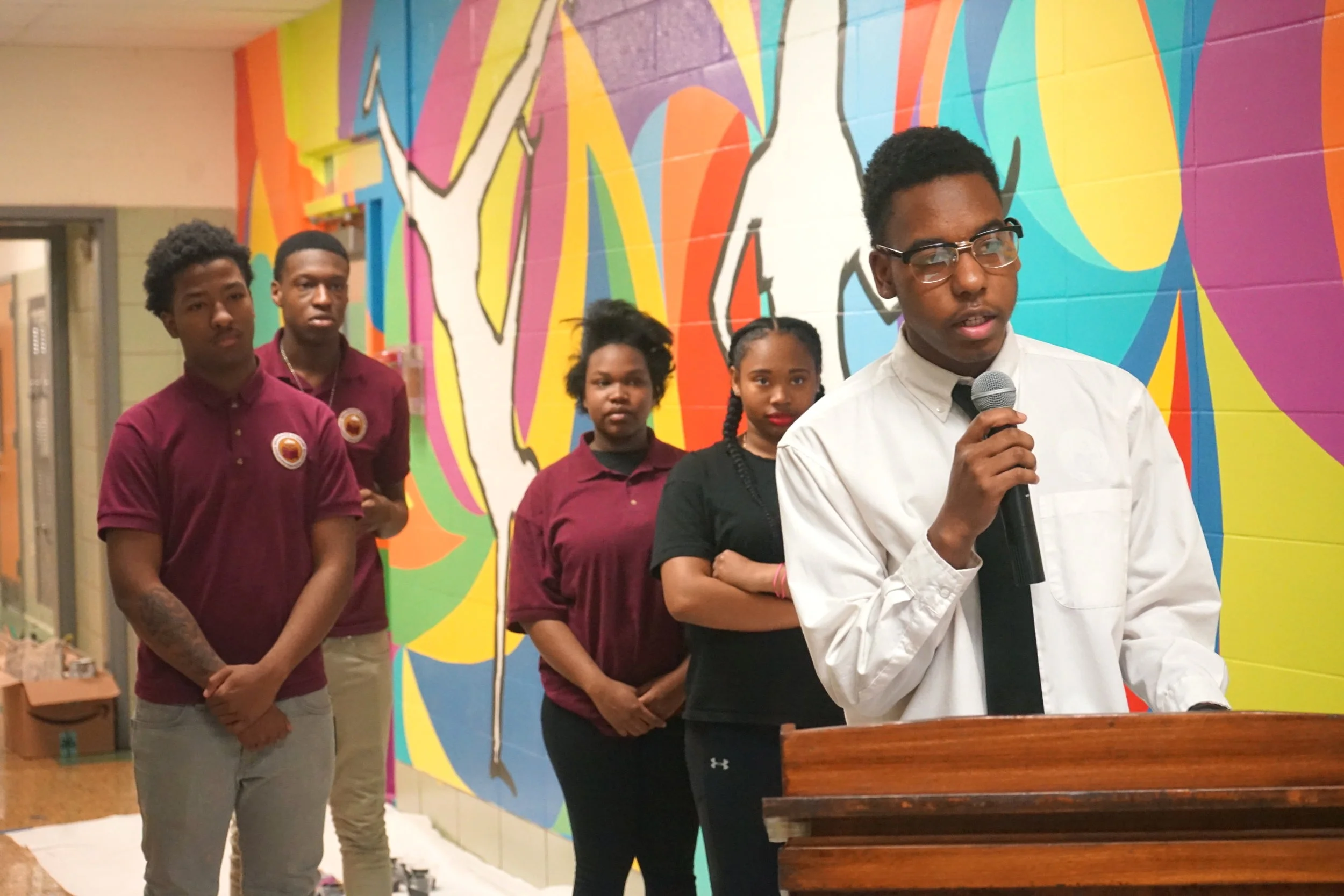 With the support of his classmates behind him, Kevin Flemming, a junior at Renaissance Academy delivers his speech to the audience during the mural unveiling.