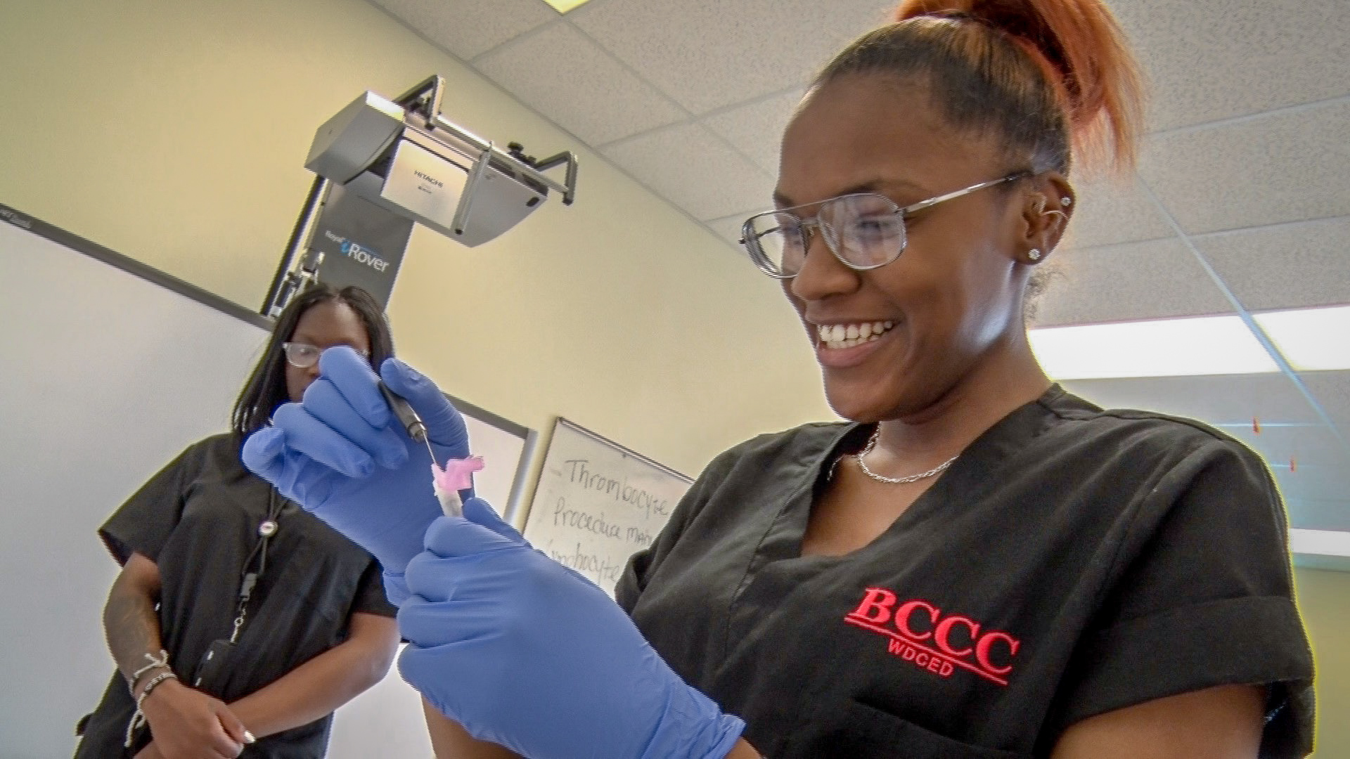 Photo caption: Two Renaissance Academy High School students participate in a mini-clinical laboratory that is inside the school and is equipped with all the things needed to learn phlebotomy such as needles, mannequin arms and hands to practice drawing counterfeit blood from.