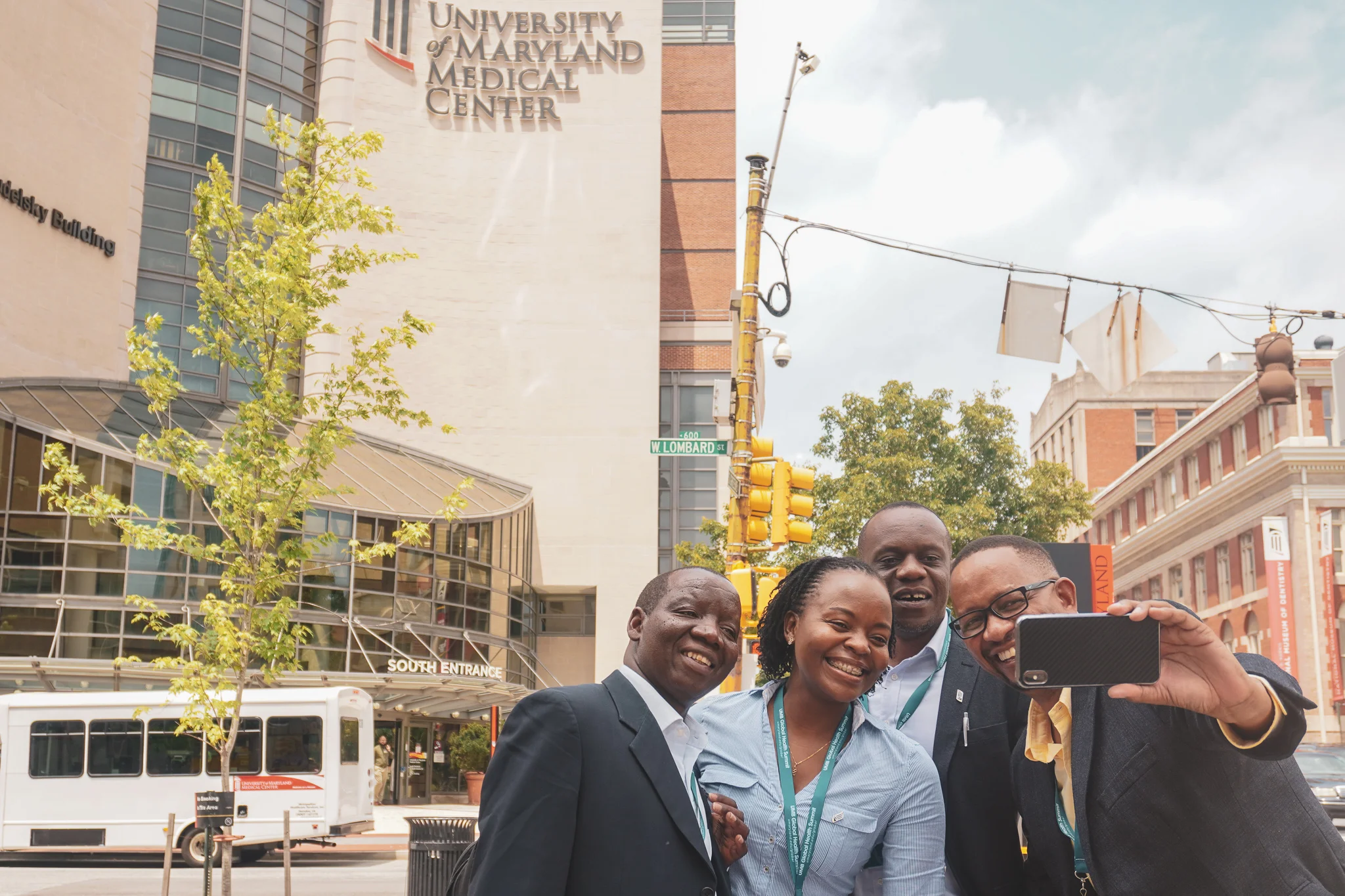Photo Caption: After a tour around West Baltimore, four members of the delegation from African countries stop outside the University of Maryland Medical Center for “selfies” and light-hearted smiles.