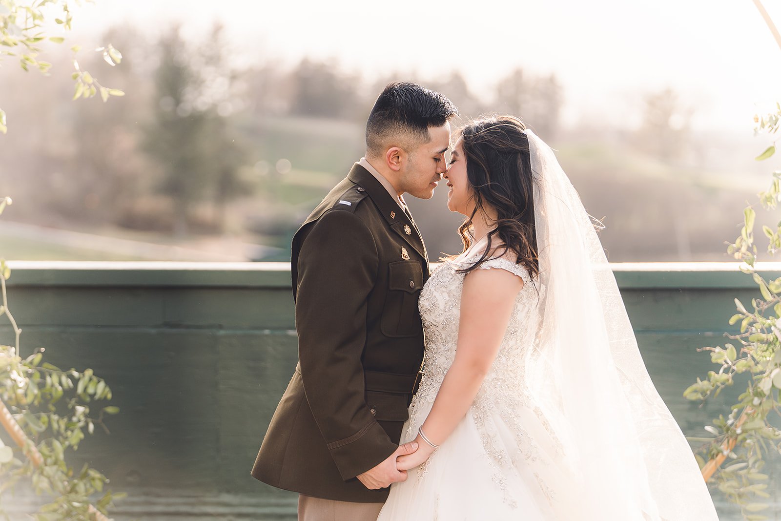  An Asian Bride and Groom share a sweet moment in the sunlight on their wedding day 