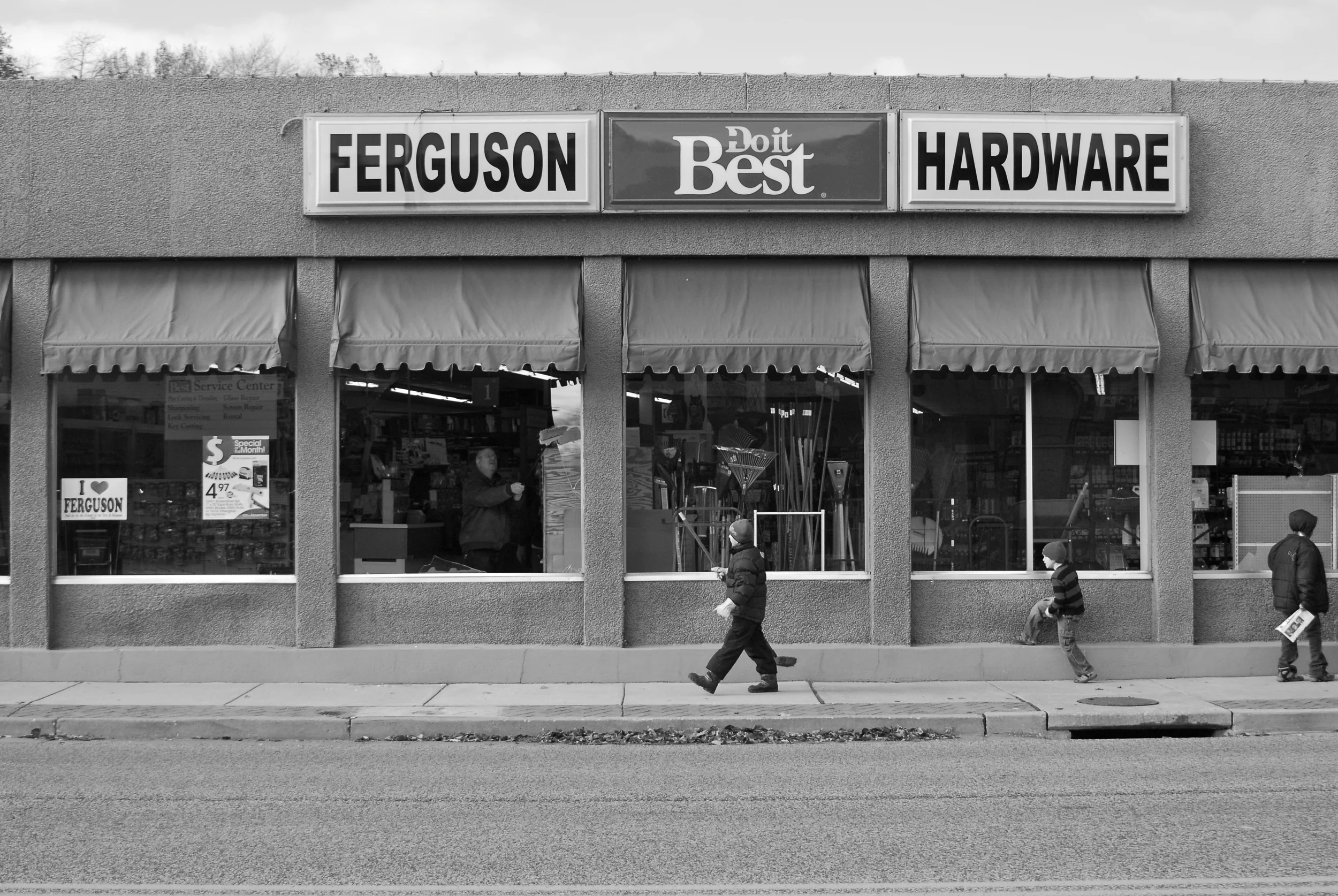  Ferguson residents begin to clean up by sweeping and boarding up broken windows following the riots that took place the night before. 