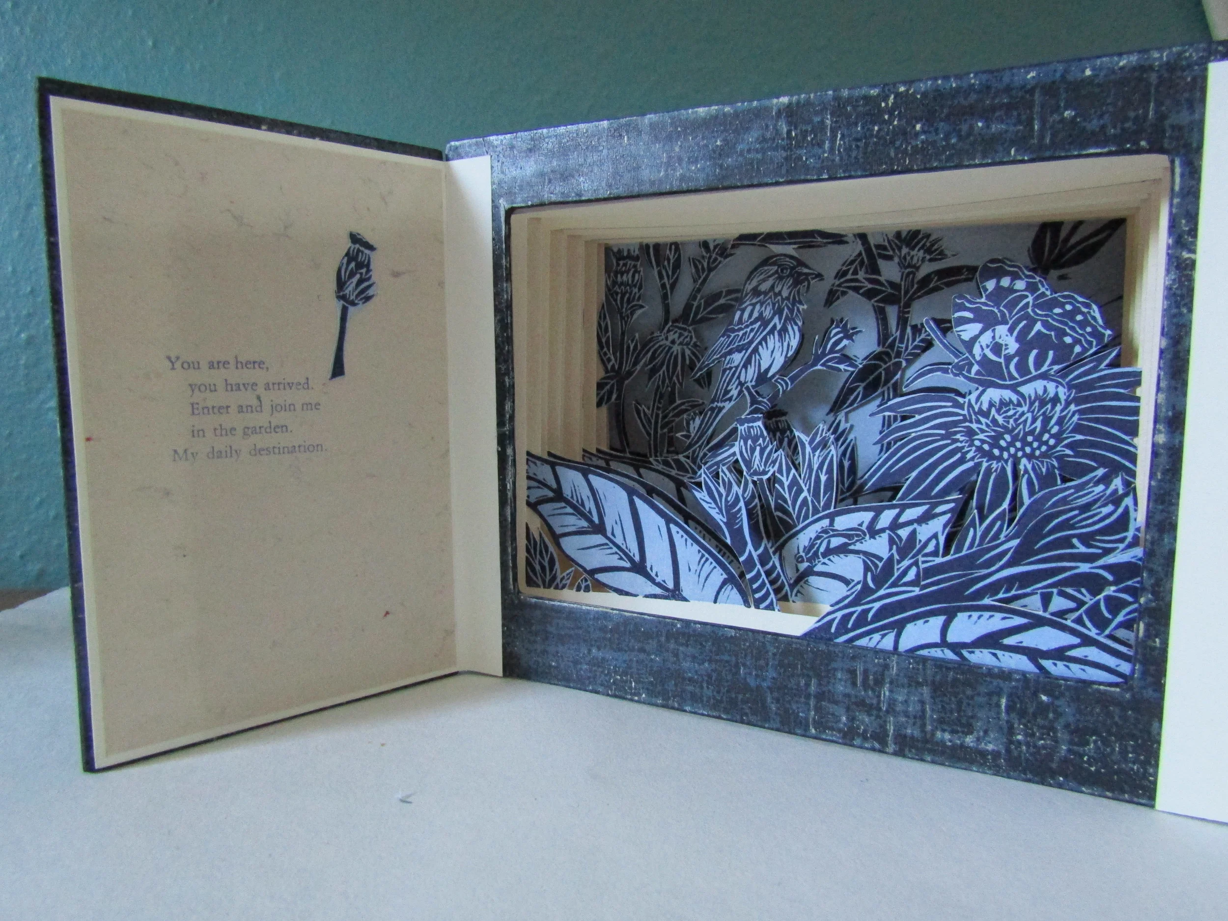 Note how the side panels of a tunnel book are accordion folded papers. This allows for the layering of the book pages and their forward extension (view 2).