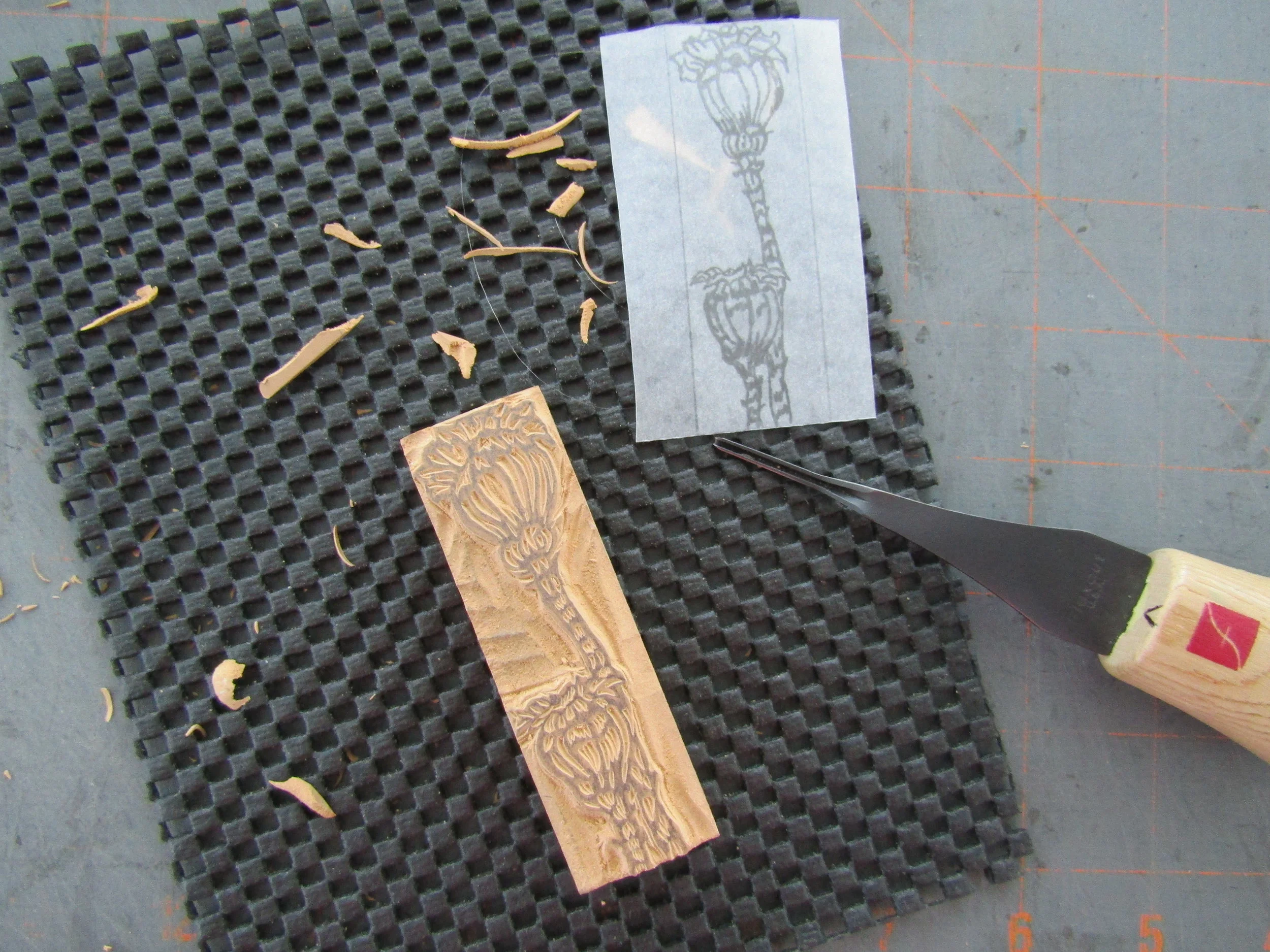 Carving a small block based on the sketch of the poppy pods.