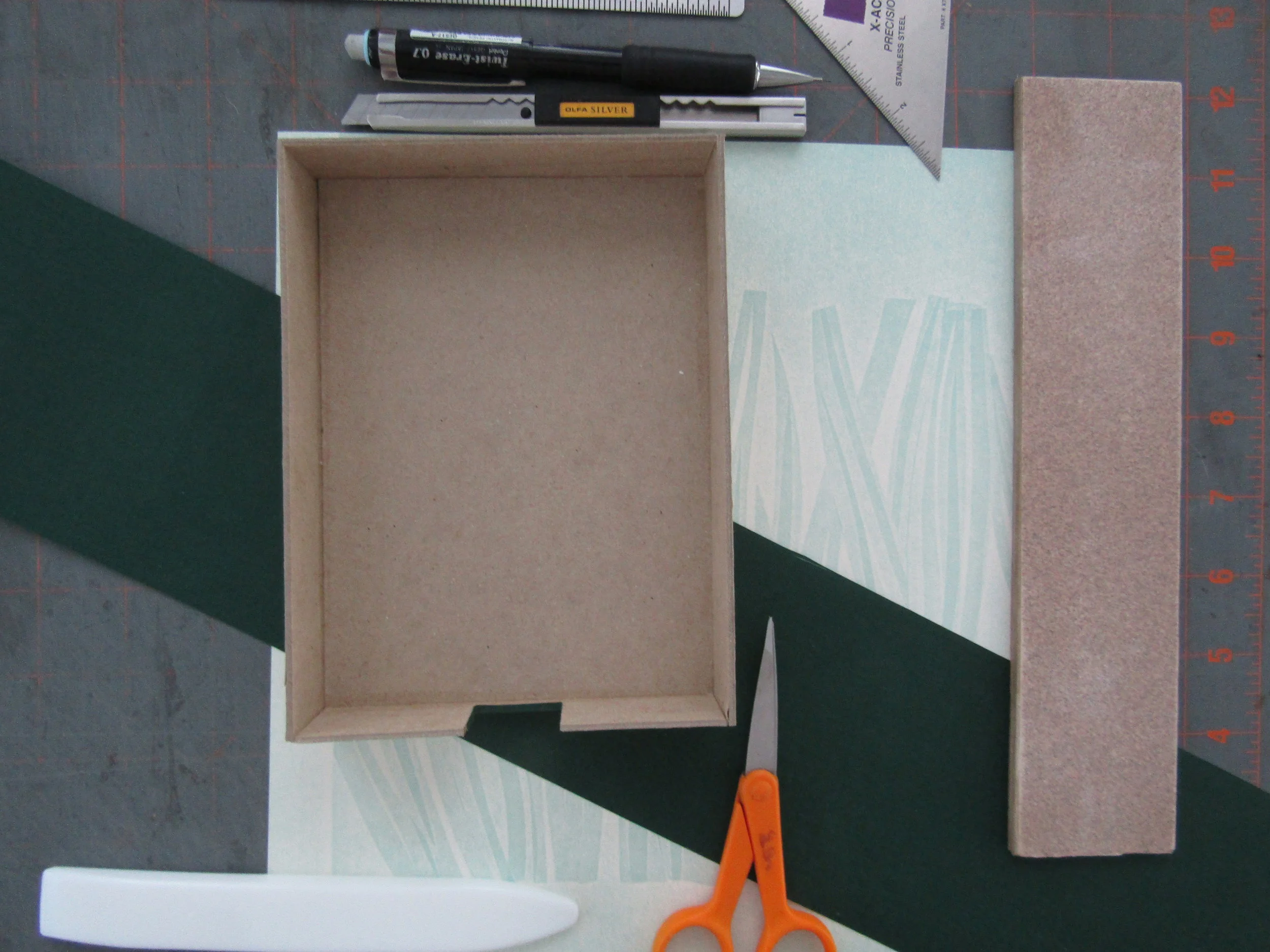 I am now at the final step - making the hinged box. I cut a small opening in the end of the box tray to help in lifting the book out of the box. 