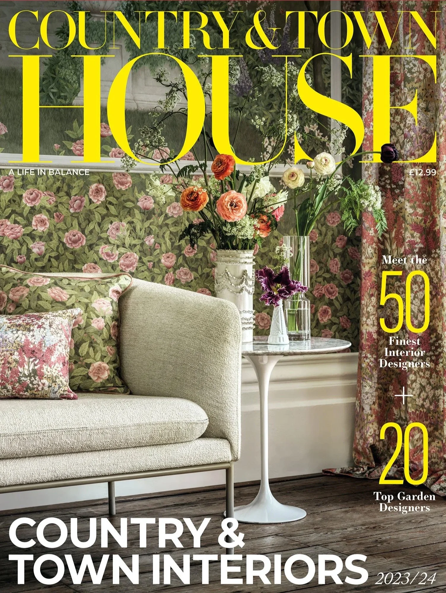 Magazine cover titled "Country & Town House," featuring an interior design scene with a beige sofa, floral-patterned pillows, a white side table, and a vase of colorful flowers. The text highlights the 50 finest interior designers and 20 top garden designers for 2023/24.