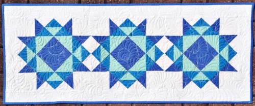 Three blocks set together without sashing and a small outer border makes a perfect table runner!