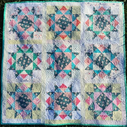 In this version, I used the blocks set together with a narrower sashing and borders to make a baby quilt. I also loved how the scrappy look worked so well with this pattern! :) See my video tutorial for the quilting design shown here, called Ripples.