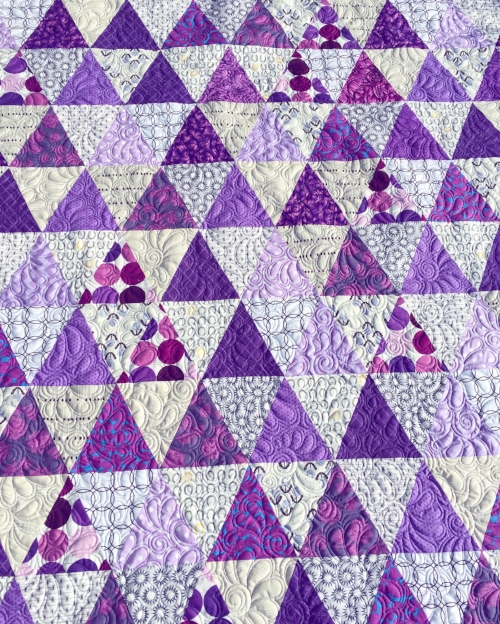 Purple triangle quilt made with Tri-Recs rulers, free-motion quilting tutorial here: feathered spirals