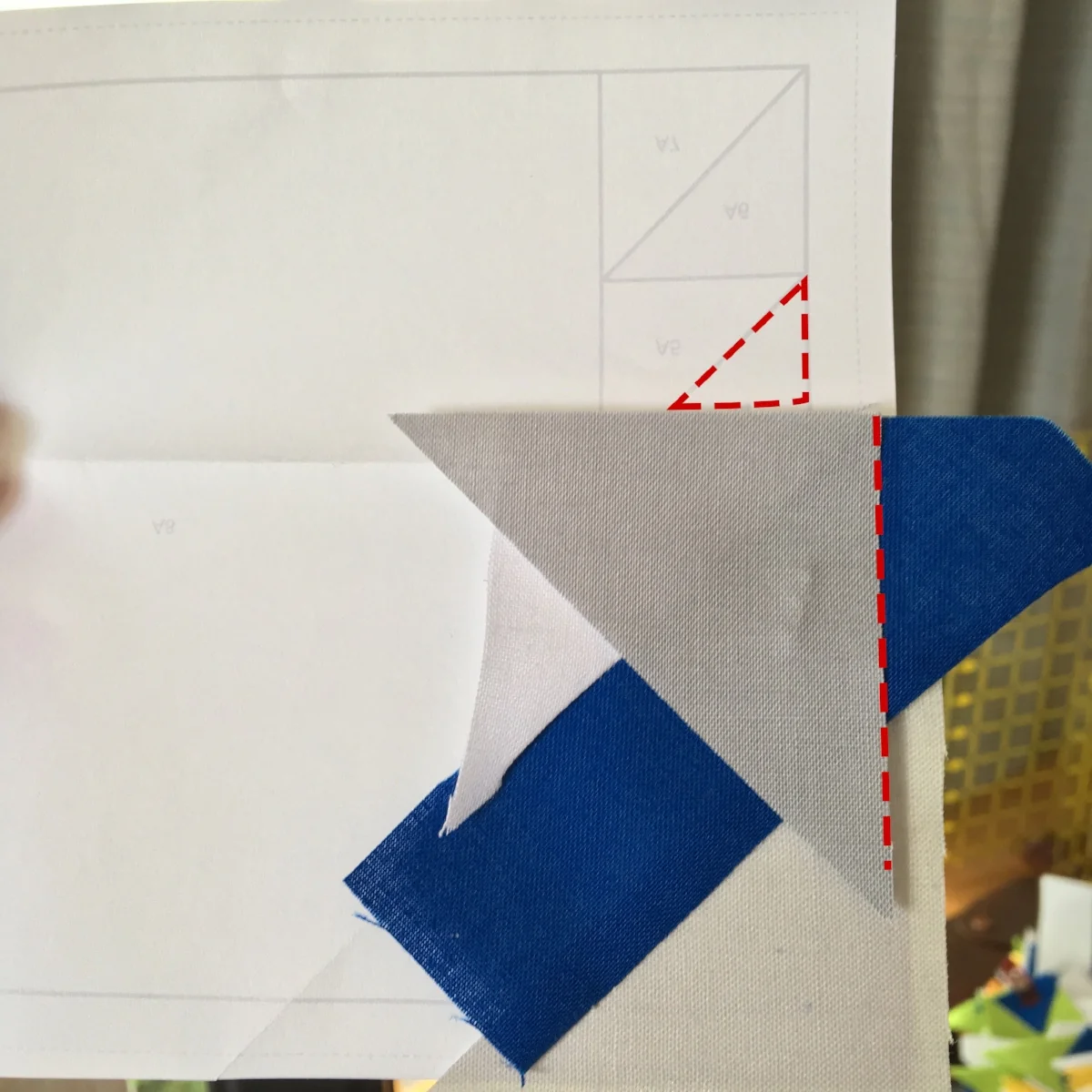When I'm piecing spines, I think in terms of covering the "upright" triangle (outlined in red dashed lines). I make sure the new triangle is "leg-down". Also, it's important to note that I'm making sure I cover the 1/4" seam allowance on both the right (unmarked) and left side of this spine.