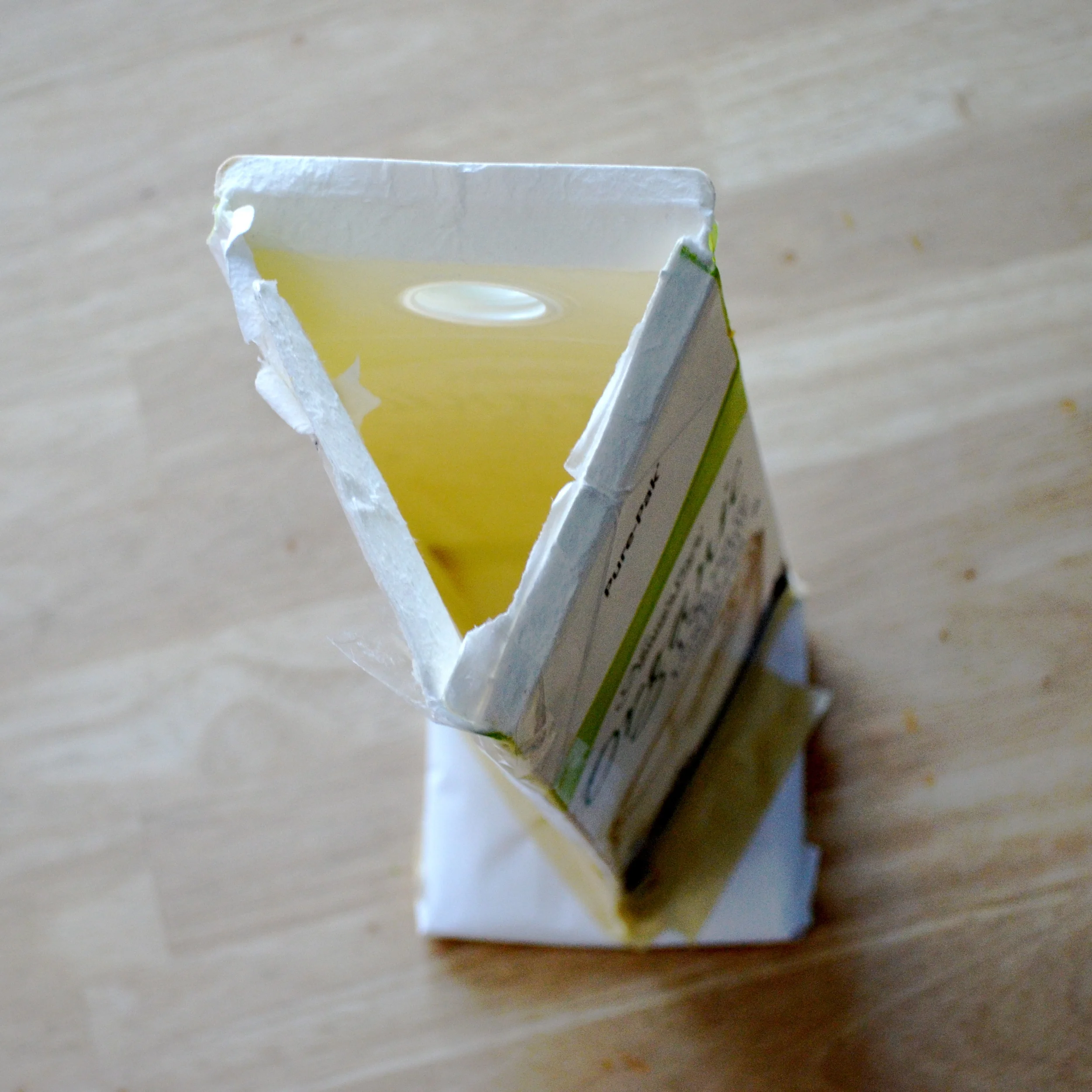 And now, the triangle milk carton stands tall to be fixed to the bottom of the carton by some masking tape.