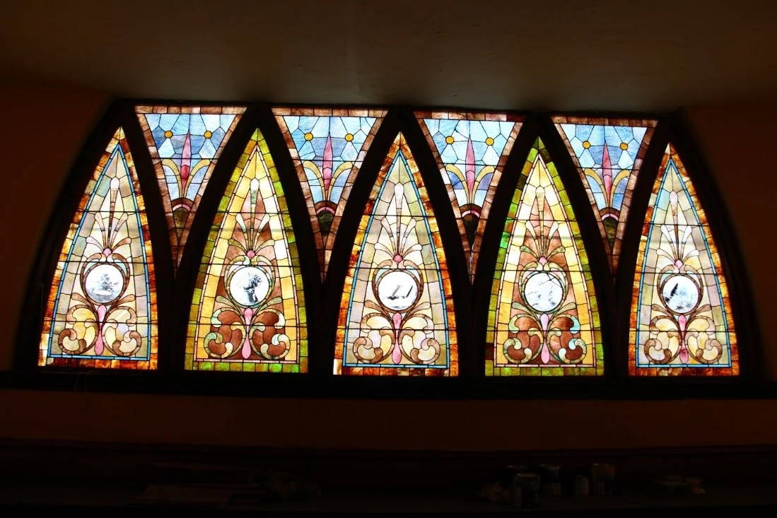 58 View north, showing detail of balcony stained glass window; the arched sashes are operable via a center horizontal pivot.jpg