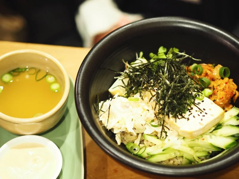 Kimchi Dragon Bowl: Biodynamic brown rice, topped with kimchi, coleslaw, micro-salad, cucumber, organic tofu, sesame oil and nori. Served with cashew cream + chickpea miso soup.