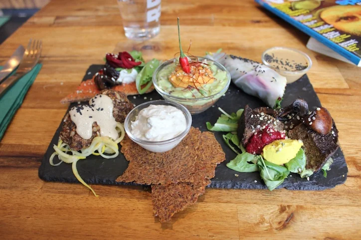 Raw Tasting Plate at Rawtastic featuring raw pizza, tex mex bowl, rainbow rolls, mushroom burger, falafel, flax crackers & cashew cheese.