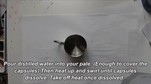 Water size is the "glue" that adheres gold leaf sheets to glass, and it needs to be prepared fresh before each application of gold. Water Size Preparation : First, take apart the two halves of two capsules, and soak them in cold/room temp. distilled water for a couple minutes (just enough water to cover the capsules). The capsules won't dissolve into the cold water, but you will notice that they increase in size and get flimsy. Now, hold the stainless steal mug over top a medium flame about 1" away while constantly swirling the mixture. After a couple minutes, you will notice the capsules beginning to fully dissolve into the water. Cook the mixture until there are no visual remnants of the capsules. Then you can add more cold distilled water to the mixture to increase volume.
